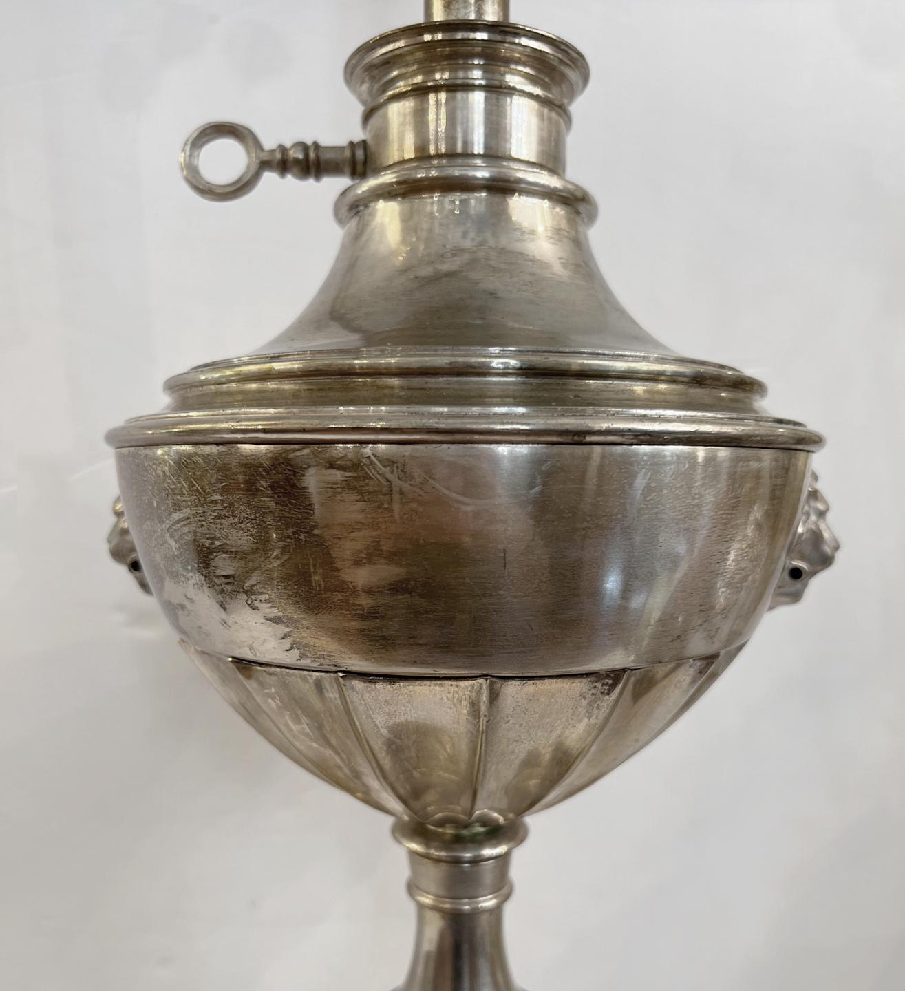 Une seule lampe de table anglaise en métal argenté datant des années 1920 avec des masques de lion sur le corps.

Mesures :
Hauteur du corps : 22
Hauteur du reste de l'abat-jour : 33