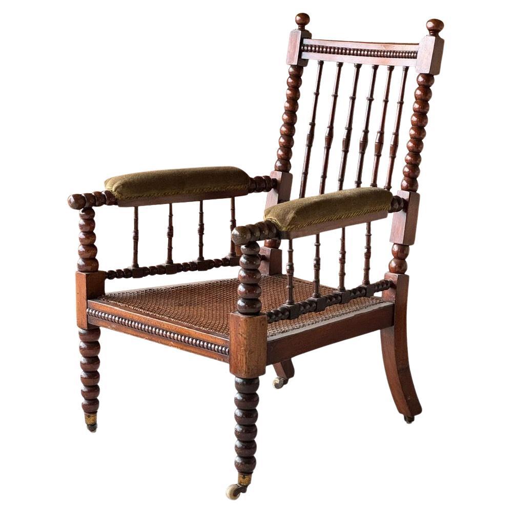 19th century English single bobbin chair.
Classic bobbin details and spindle seat back.
Cane seat.
Original four brass casters.