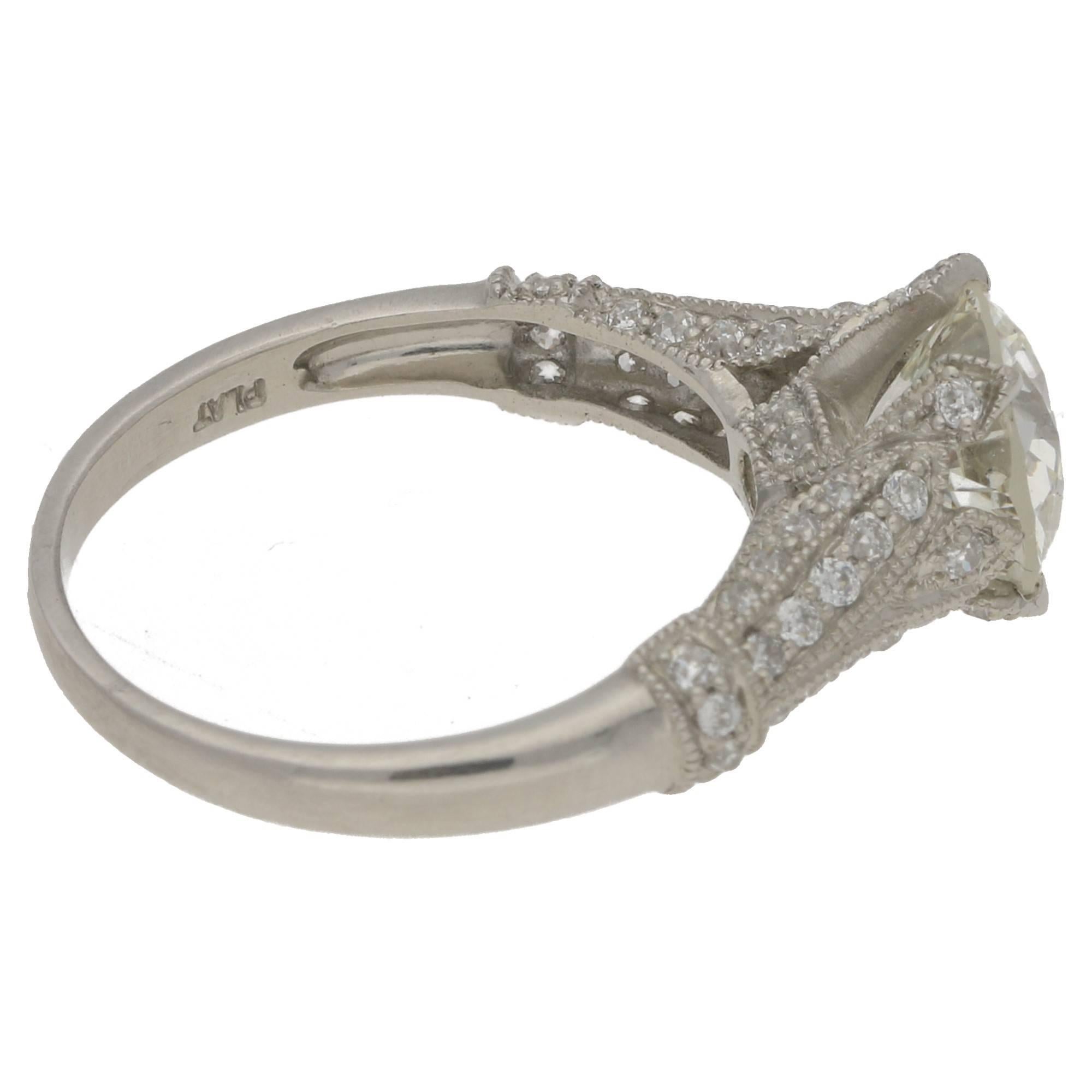 An Edwardian style platinum ring featuring an Old European cut diamond in a four pointed claw setting with diamond grain set shoulders. The centre diamond is independently certified by GCS as 1.84 carats and L colour and Si1 clarity and has