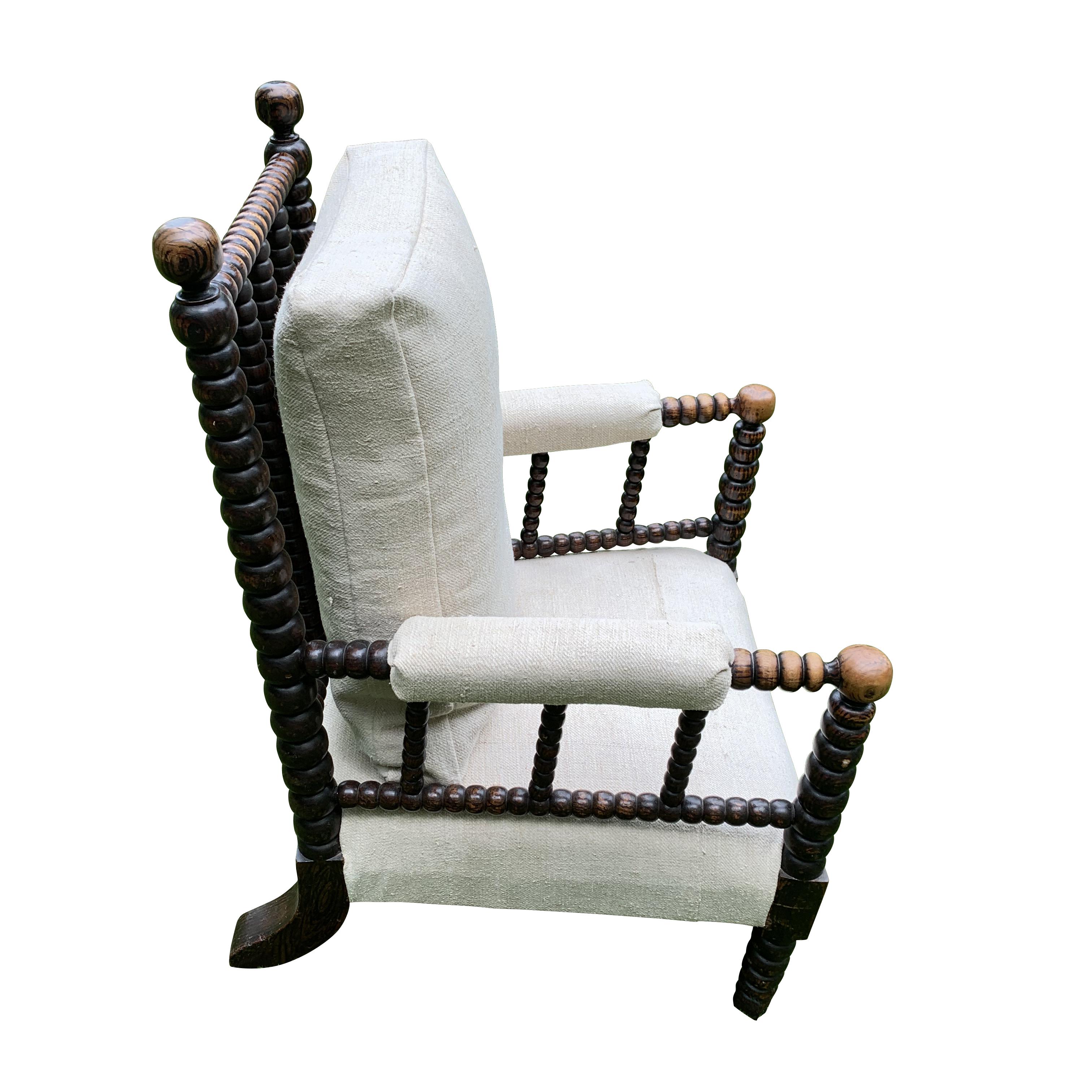 19th century English single upholstered bobbin armchair.
Bobbins appear on the exposed back frame making it as beautiful from behind as it is from the front.
Bobbins also appear on the legs and padded arms.
The chair is reupholstered in natural
