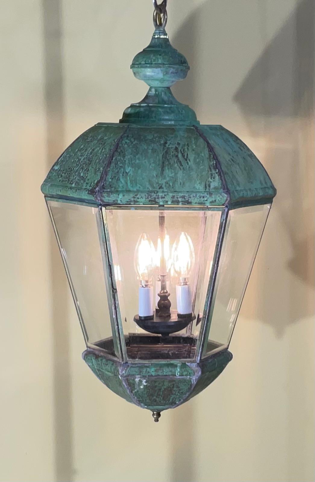 elegant hanging lantern made of solid brass, with three 40/watt lights 
Original clear beveled glass sides.
Very nice patina 
a handcrafted brass like this lantern is more than just a lighting fixture; it's a statement piece that enhances your
