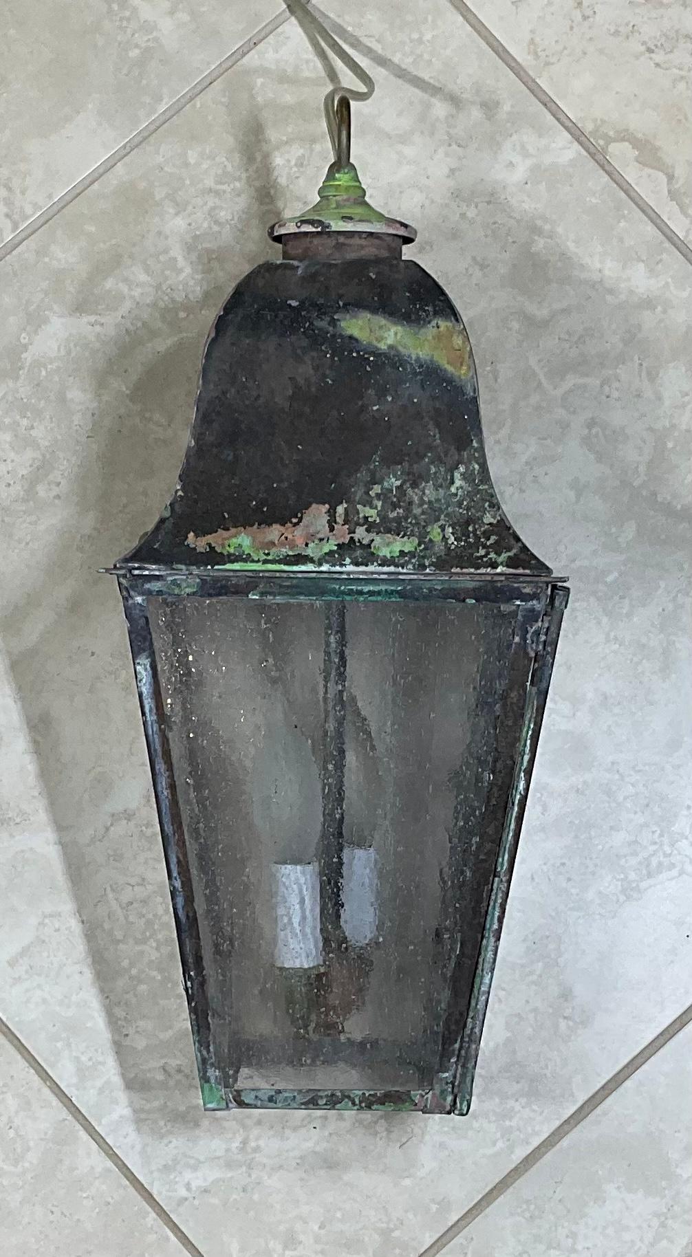 Elegante Hängelaterne aus massivem Messing, mit zwei 60-Watt-Leuchten, für Feuchträume geeignet, gebrauchsfertig, mit oxidierter Patina und getriebenem Glas.
Neu verkabelt und sofort einsatzbereit.
 