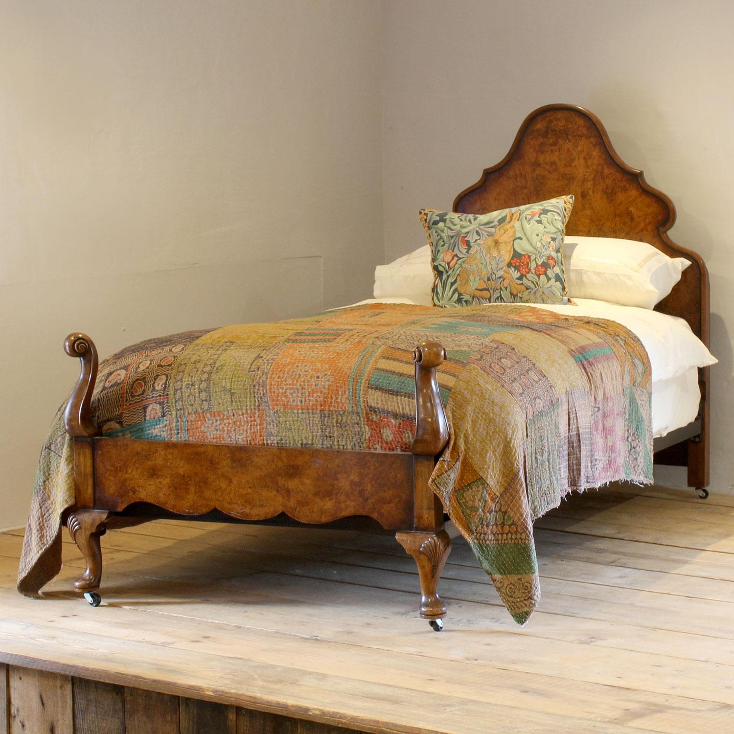 A Queen Anne style walnut bedstead with torchon feet and shaped backboard with veneered panels.

This bed accepts a standard UK single 36