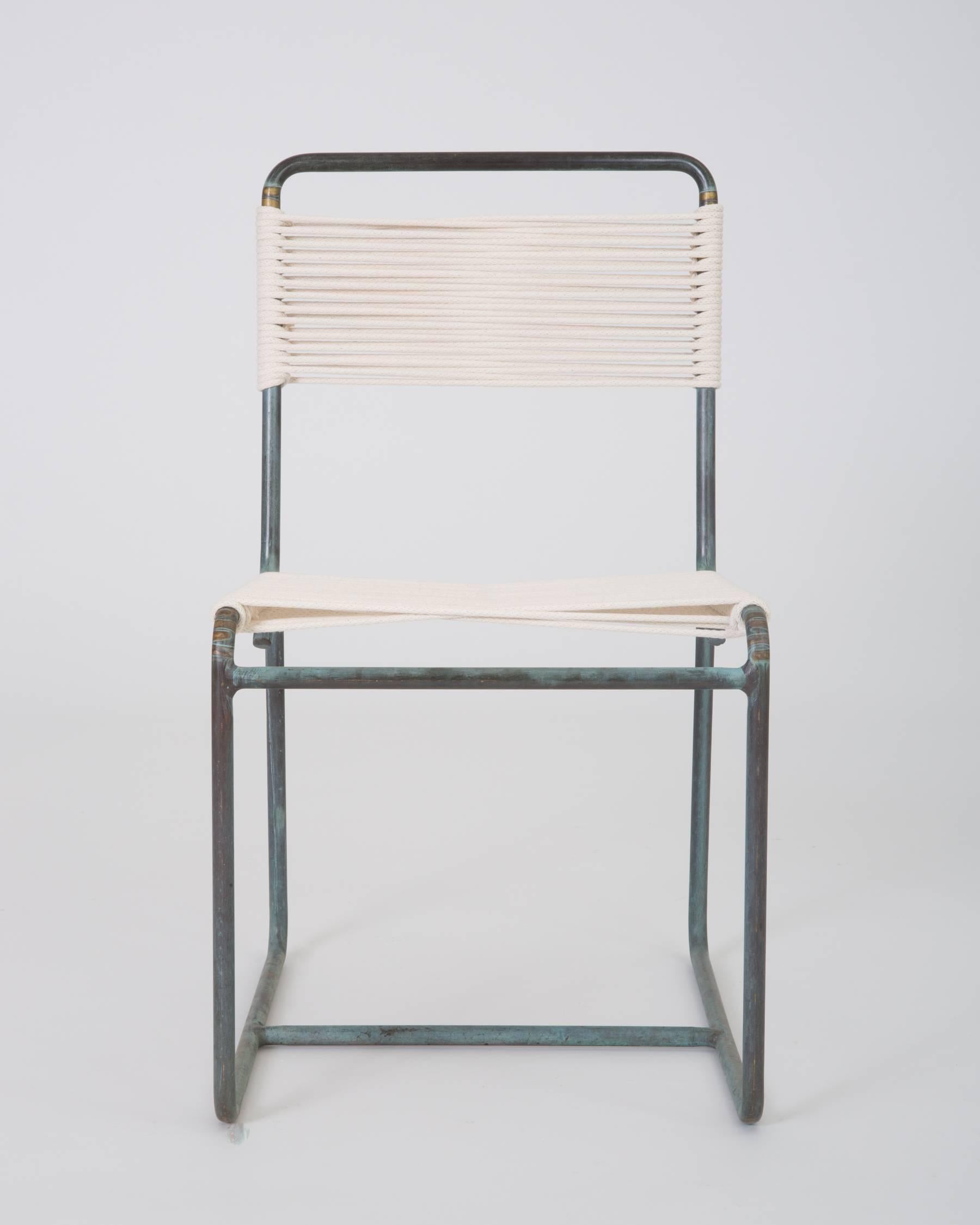 A patio dining side chair in patinated bronze, designed by Walter Lamb and produced by Brown Jordan. The chair has a tubular frame supported by bent bronze runners, with each end terminating in a stylistic curlicue. The strung seat and backrest are