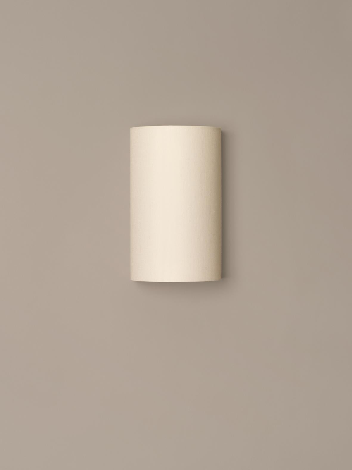 Singular wall lamp by Miguel Milá
Dimensions: D 18 x W 15.5 x H 30 cm
Materials: Metal, linen.

A lightweight shade of white linen conceals a chrome-plated structure that holds the light source, with clean lines than conceal all and show
