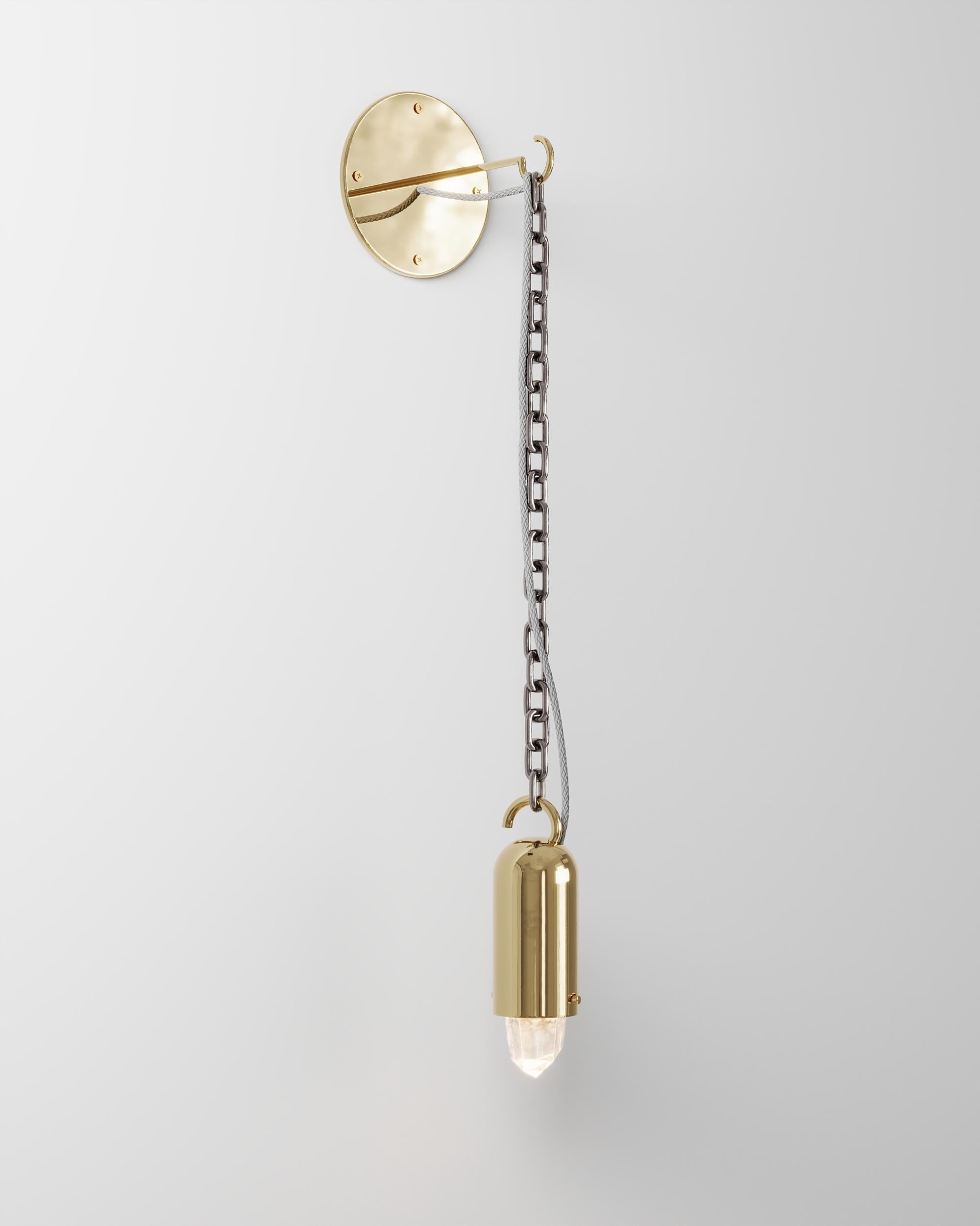 Lámpara de pared Sino Corrente de Studio Orth
Dimensiones: An 24 x Pr 20 x Al 100 cm
Materiales: Metal fundido, cadena de acero inoxidable y cristal de roca.
Acabados: Latón fundido pulido o Aluminio fundido pulido

También disponible en latón