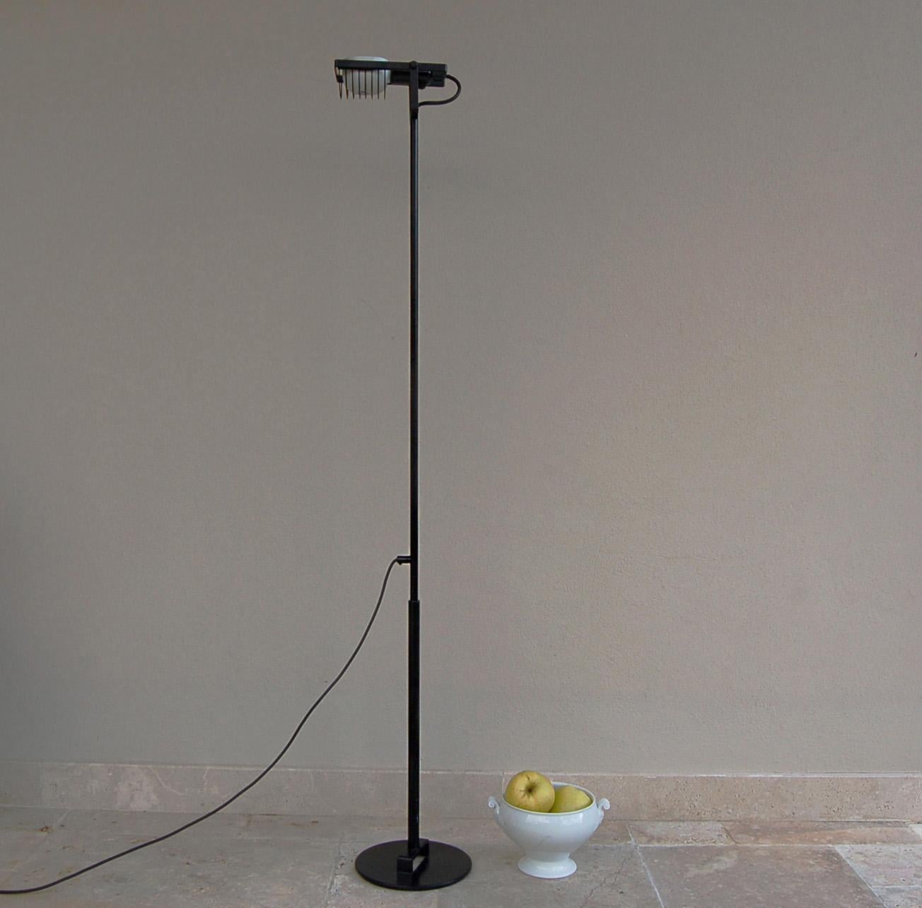 Artemide ''Sintesi terra'' is an adjustable and extendable floor lamp in black lacquered metal. This lamp is a model from 80s with silver-painted aluminum lampshade and E27 lightbulb socket. Height varies from 147-183 cm approximate base diameter