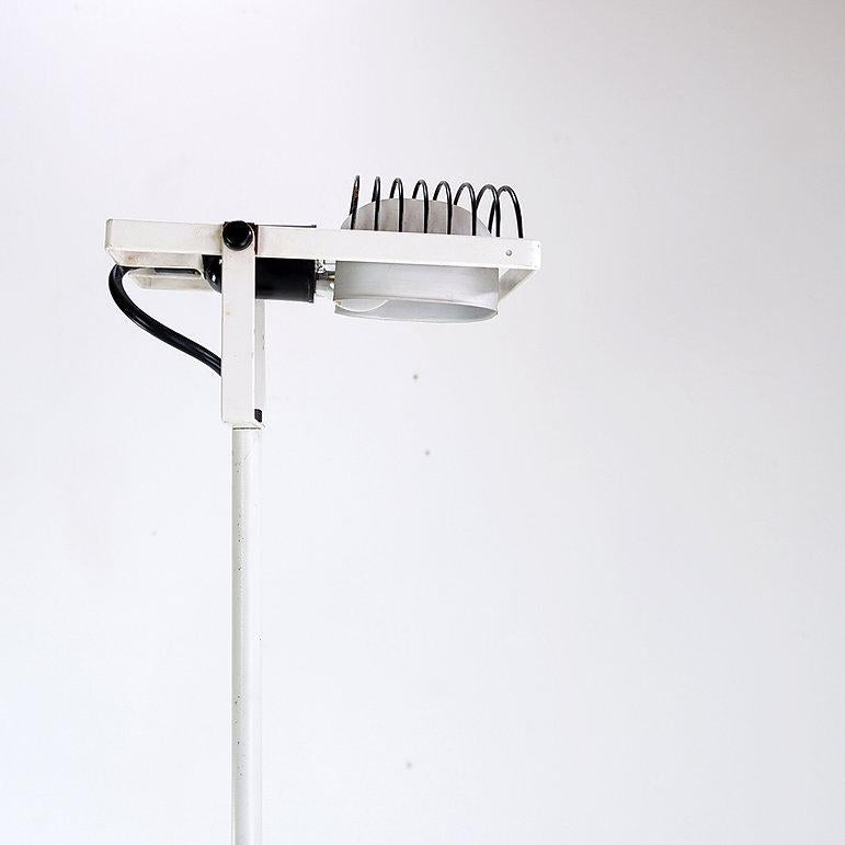 A white Sintesi Terra floor lamp by Ernesto Gismodi for Artemide, Italy, circa 1970s. This postmodern floor lamp features a white enameled metal base/head and stem and a black enameled caged housing for the bulb. An anodized aluminum shade subtly