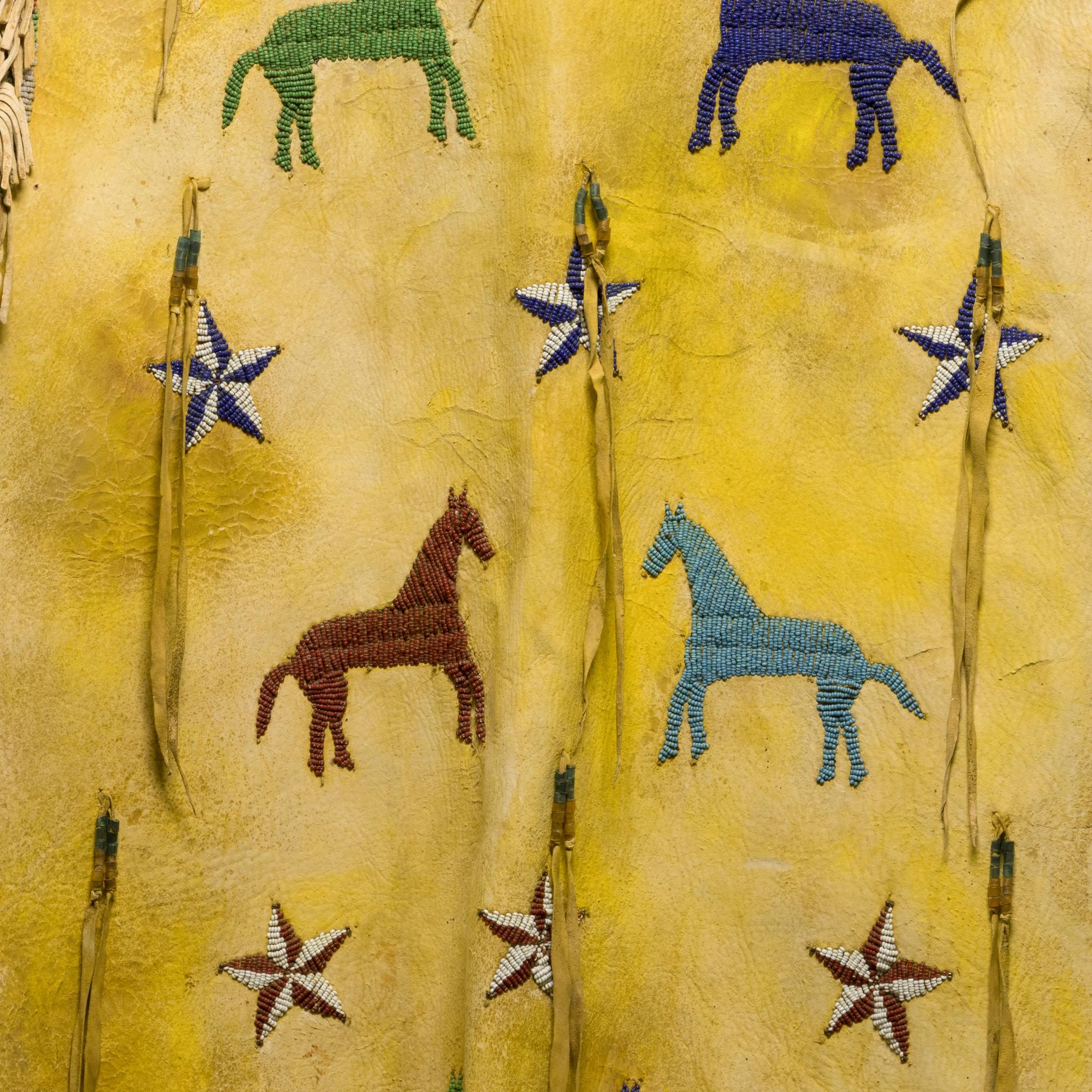 Sioux pictorial beaded tunic. Thread sewn and assembled using multiple hide panels. Beaded with 12 horses and 10 stars. Initials 