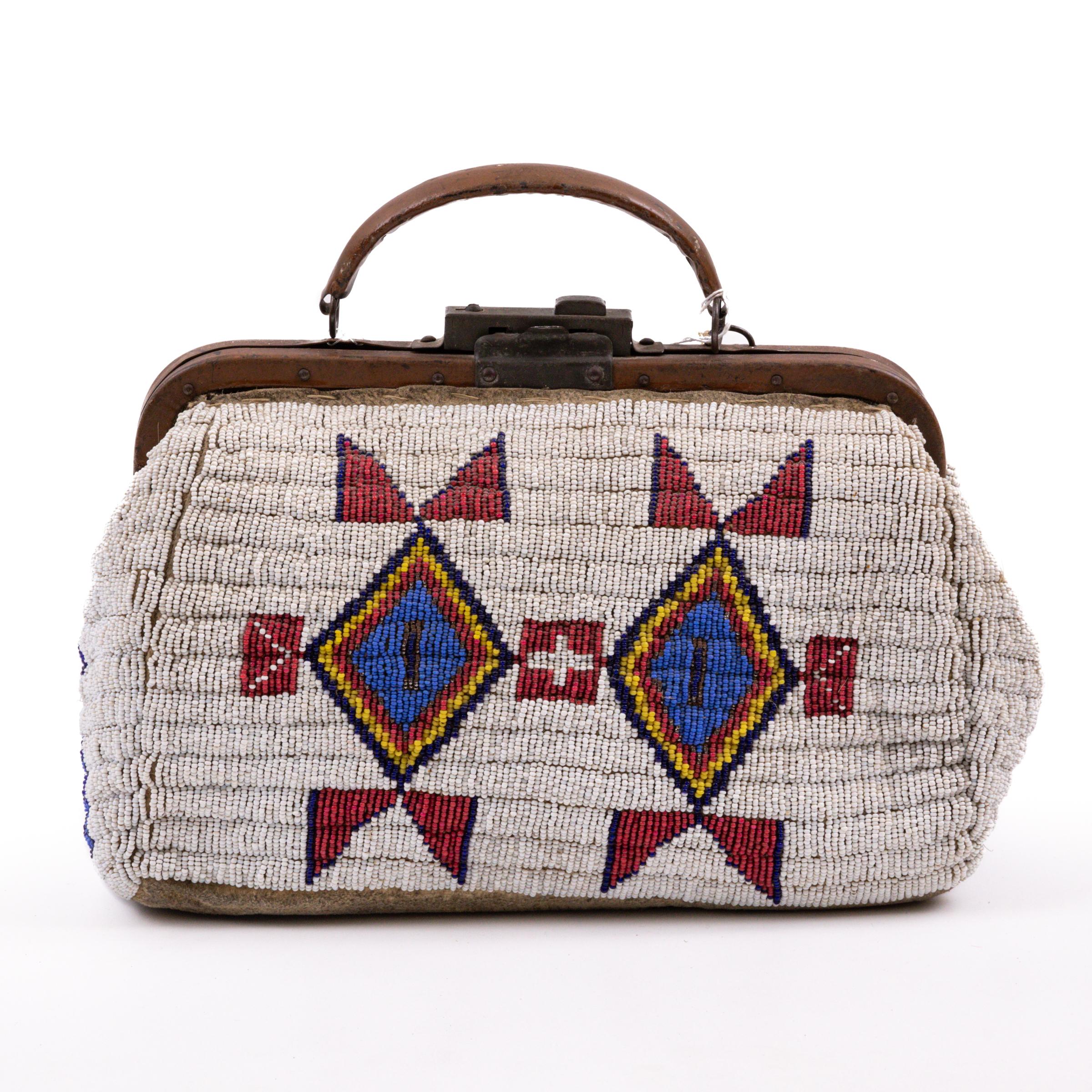 Antica borsa da medico Sioux del XIX secolo, intricata di perline commerciali in vetro veneziano, tra cui cuori bianchi, blu scuro, giallo grasso e blu, insieme a perline metalliche sfaccettate, il tutto su un campo bianco. Le perline sono cucite a