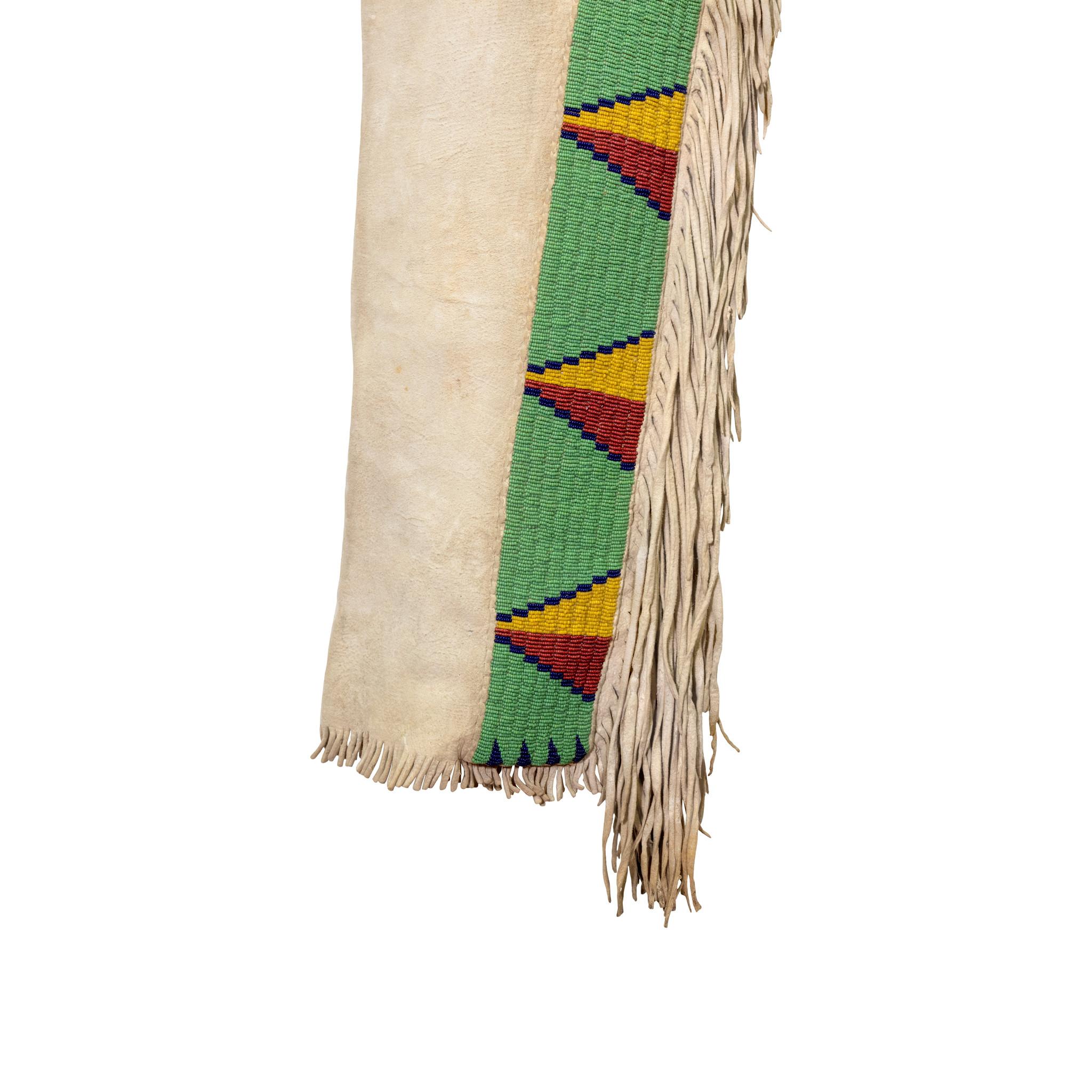 Hemd und Leggings eines Sioux-Kriegers der amerikanischen Ureinwohner des 19. Jahrhunderts aus Hirschleder. Hemd und Leggings sind hirngegerbt, das Hemd mit langen Fransen und Hermelinpelz auf Fellstümpfen. Auffällige geometrische Perlenstickerei in