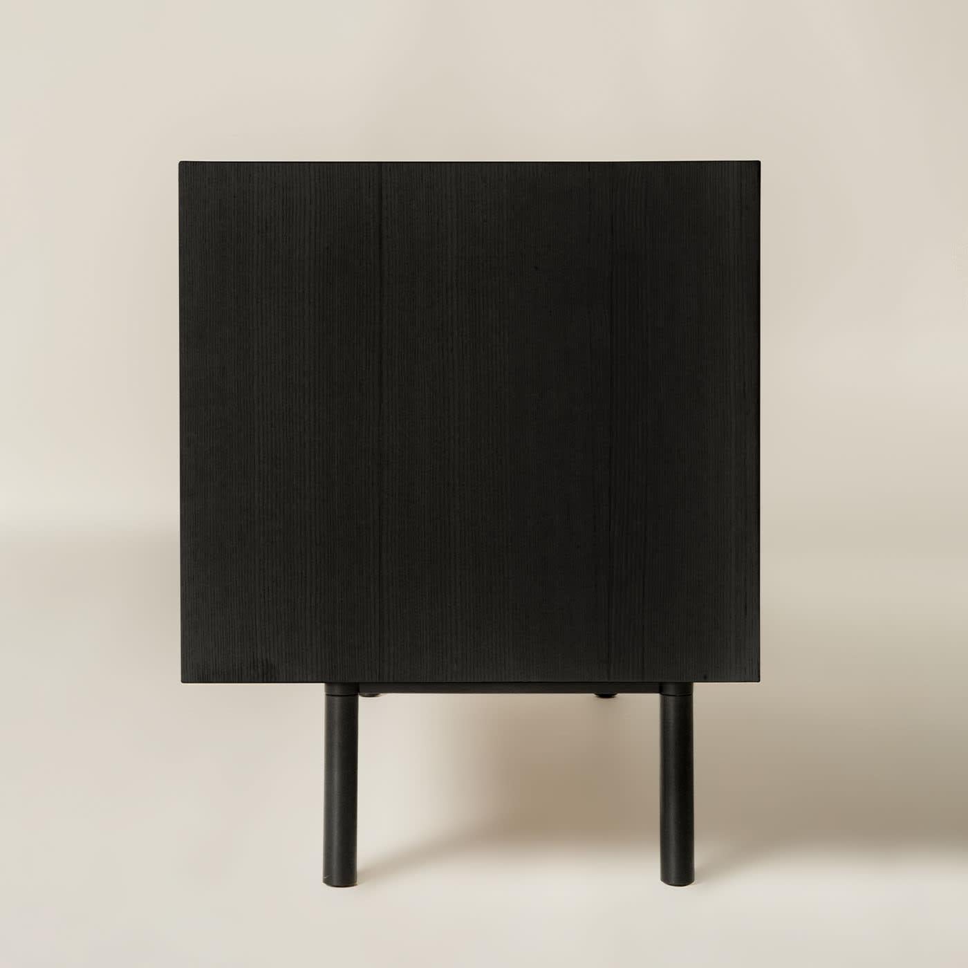 The Sipario sideboard creates a frame where the staggered layers and their vertical pattern produce a fascinating rhythm of shadows. As a result, the essence of solid ash wood reveals different details. The top is a deliberate invitation to give