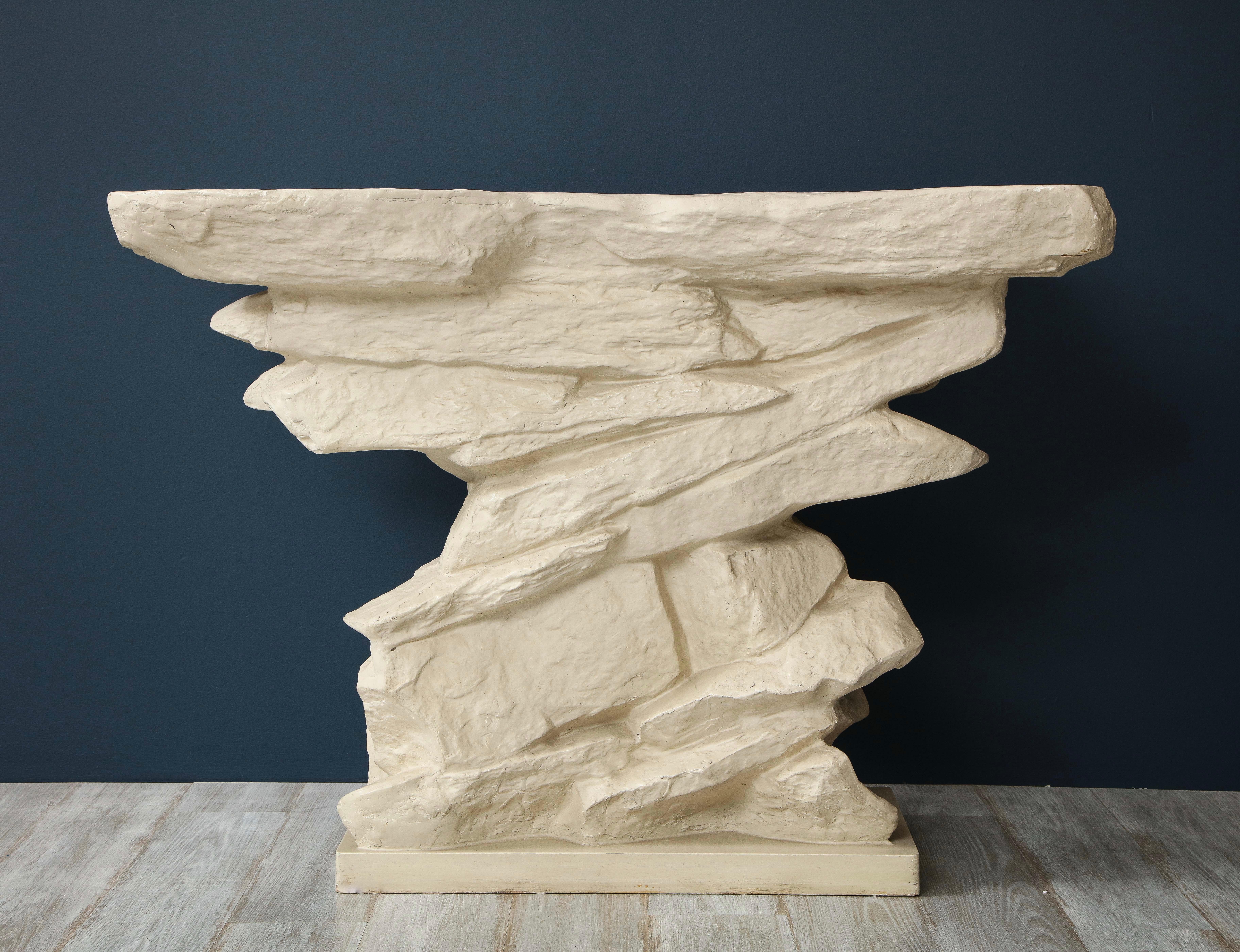 A Sirmos white painted plaster console table based on the iconic original designed by Emilio Terry in 1927. This timeless, chic console which simulates stacked rocks works with a multitude of styles including modern, transitional, midcentury and