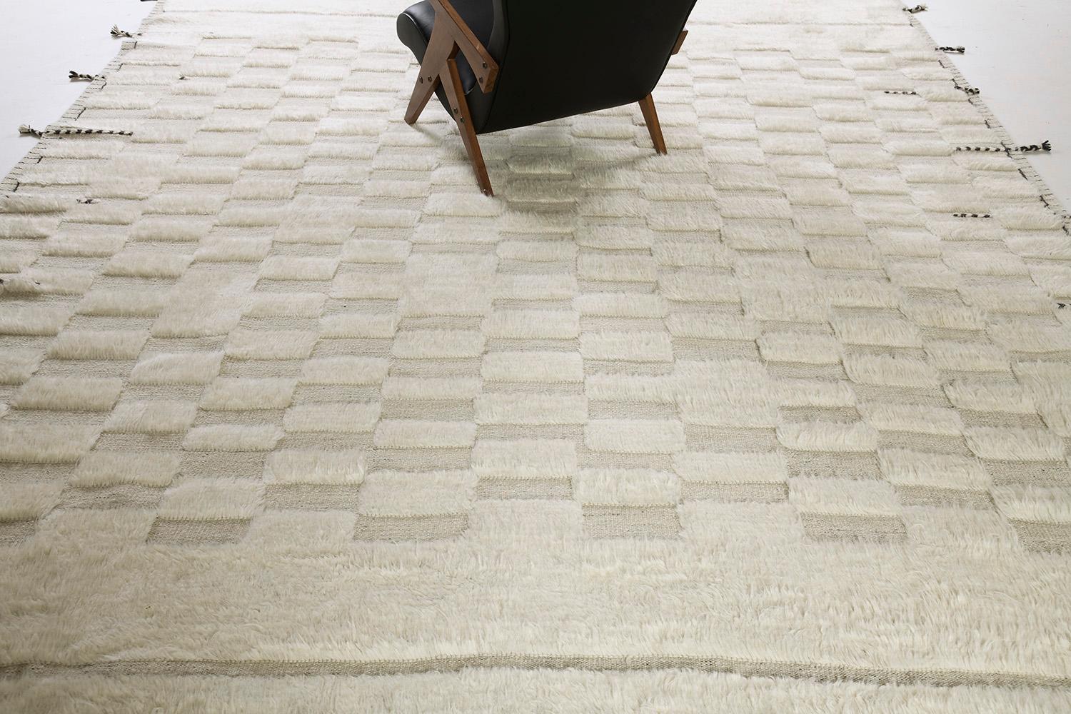 Sirocco is a stunning handwoven ivory rug with embossed detailing in a checkered pattern atop a natural gray pile weave. Beautiful tassels and bordered designs add time and one-of-a-kind essence for the modern design world. Haute Bohemian
