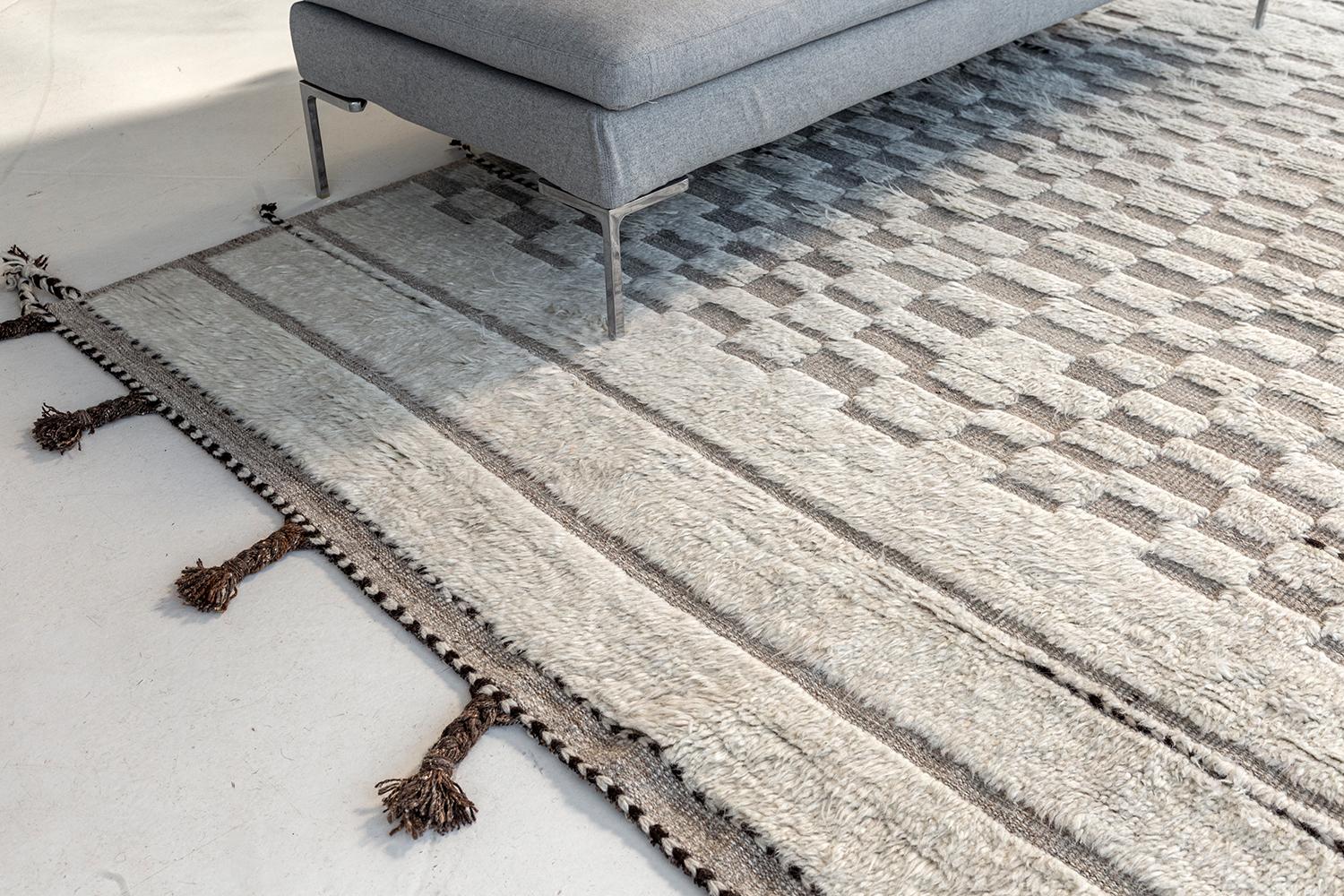 Sirocco is a stunning handwoven ivory rug with embossed detailing in a checkered pattern atop a natural gray pile weave. Beautiful tassels and bordered designs add a time and one of a kind essence for the modern design world. Haute Bohemian