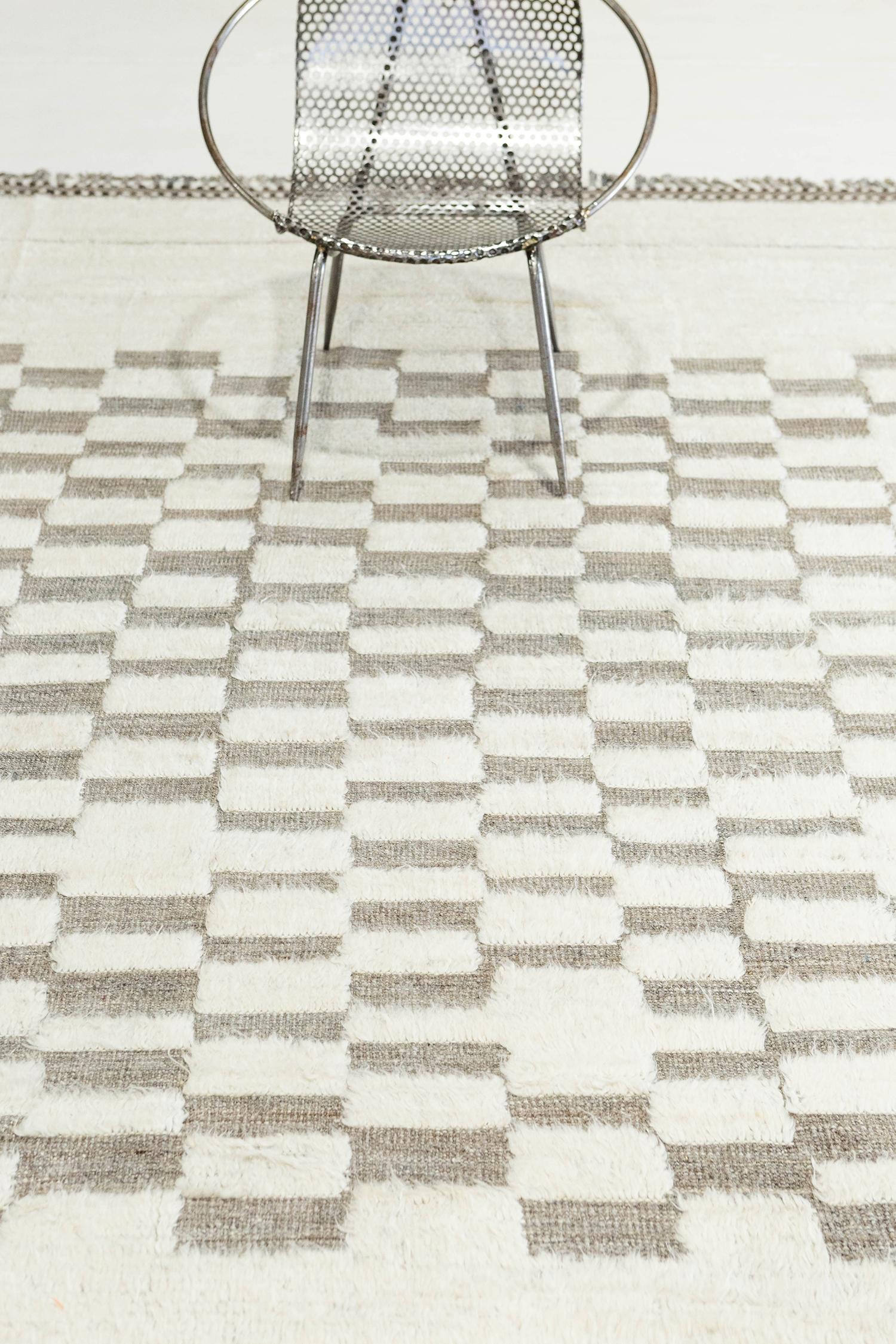 'Sirocco' è uno splendido tappeto avorio tessuto a mano con dettagli in rilievo a scacchiera su una trama naturale a pelo grigio-tomentosa. Bellissime nappe e disegni bordati aggiungono un'essenza unica e attuale al mondo del design moderno. Haute