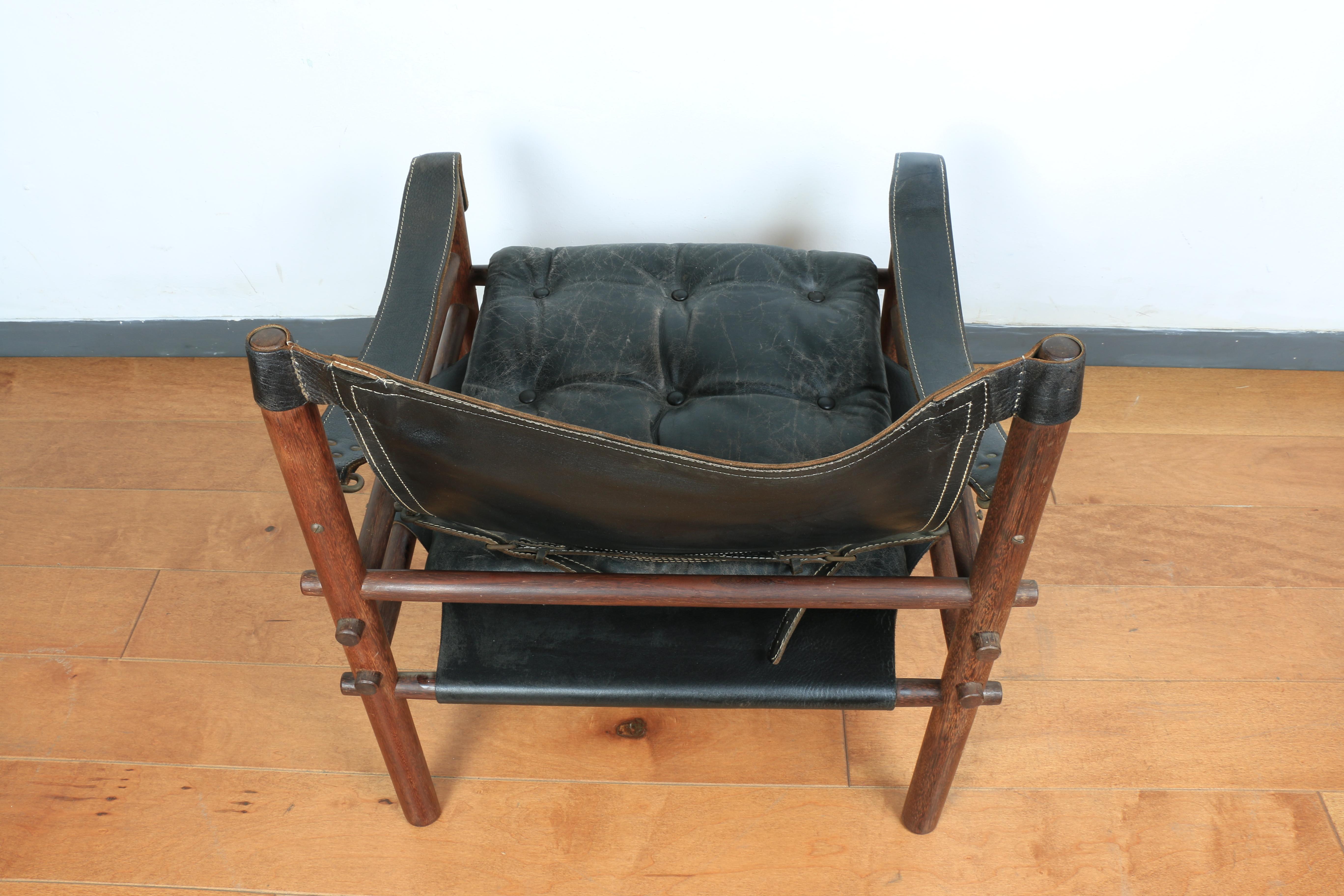 Preciosa silla Safari individual de madera de coco. Bonito diseño detallado con uniones articuladas detalladas. El cuero tiene señales de desgaste, pero sin rasgaduras. Genial para sentirte cómodo en casa. Los asientos de cuero tienen correas debajo