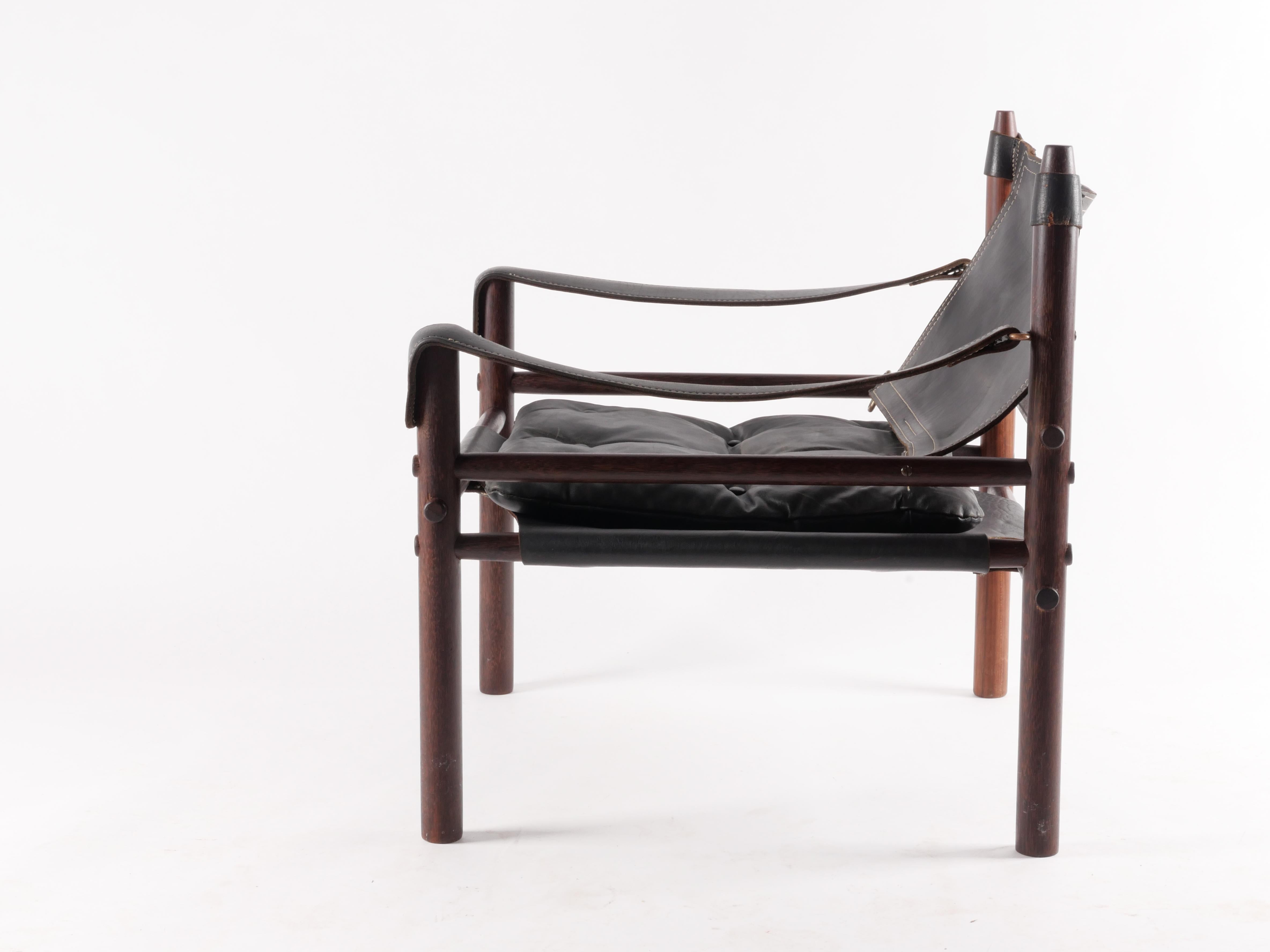 Classic black leather “Sirocco” safari chair by Arne Norell. Lovely patina to leather as well as brass fittings. Frame is solid Cocobolo. Age consistent signs of use. Versatile and very comfortable. 