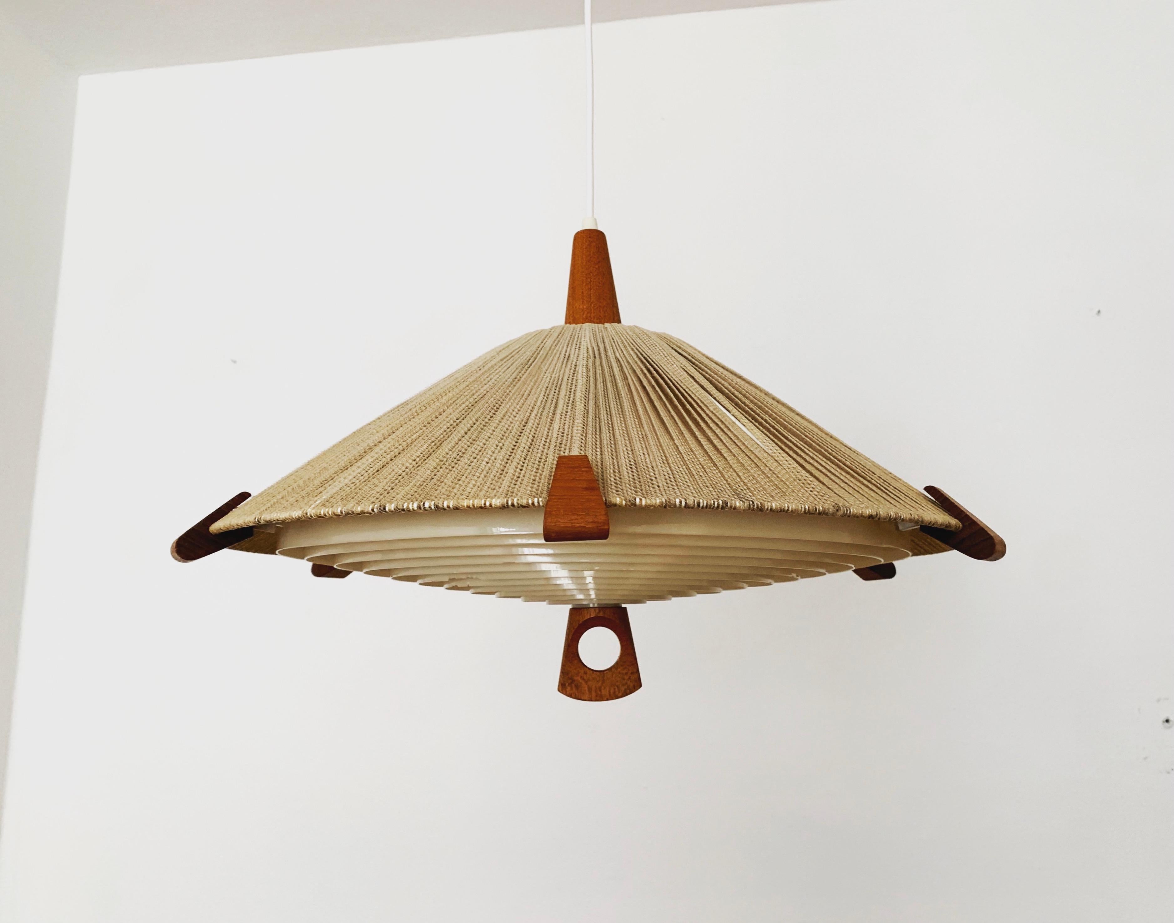 Lampada a sospensione eccezionalmente bella e molto rara degli anni '60.
Il design è molto insolito.
La forma e i materiali creano una luce calda e molto piacevole.
Particolarmente belli i dettagli in teak.

Produttore:
