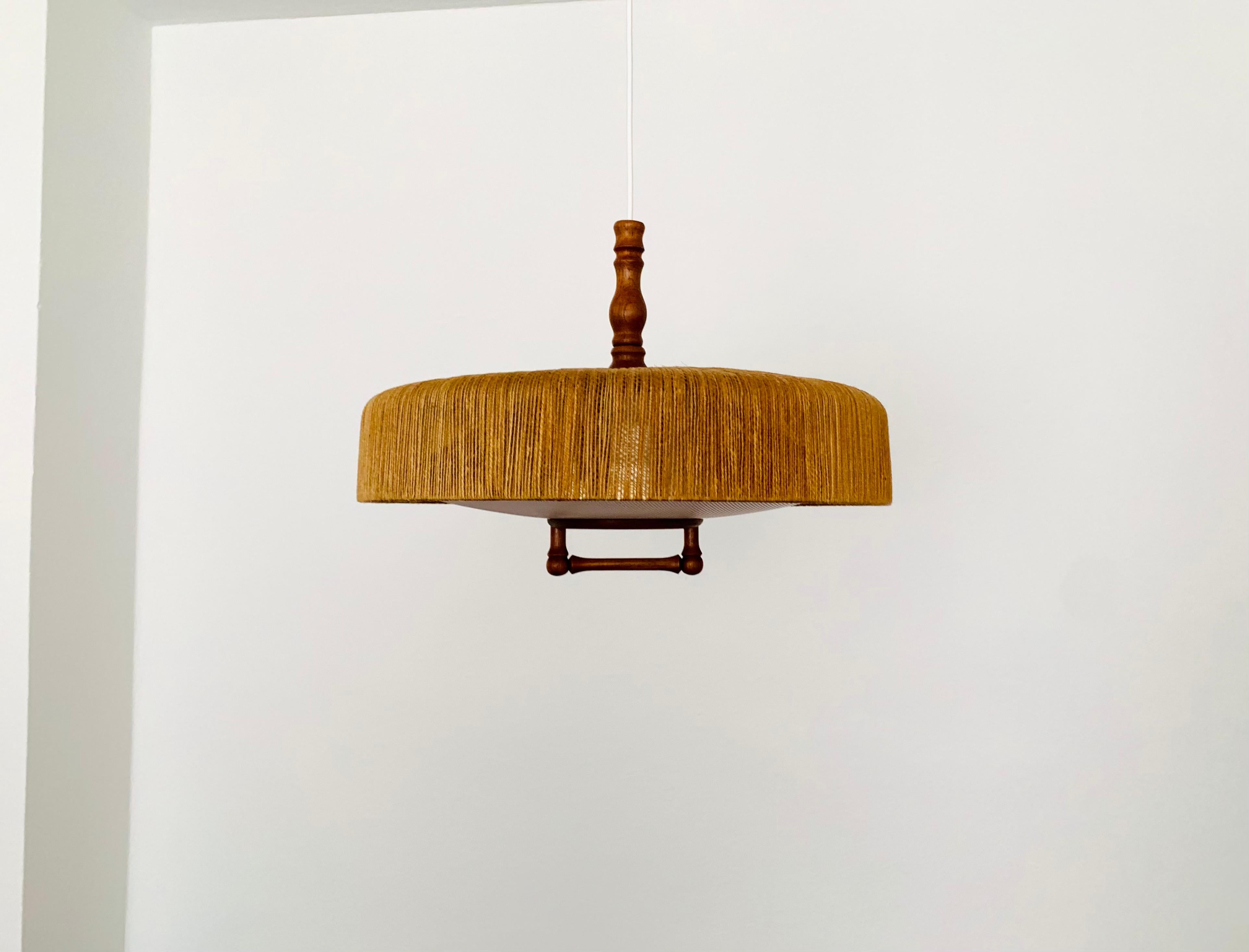 Exceptionally beautiful and large pendant lamp from the 1960s.
The design is very unusual.
The shape and the materials create a warm and very pleasant light.
The teak details are beautifully shaped.

Condition:

Very good vintage condition with