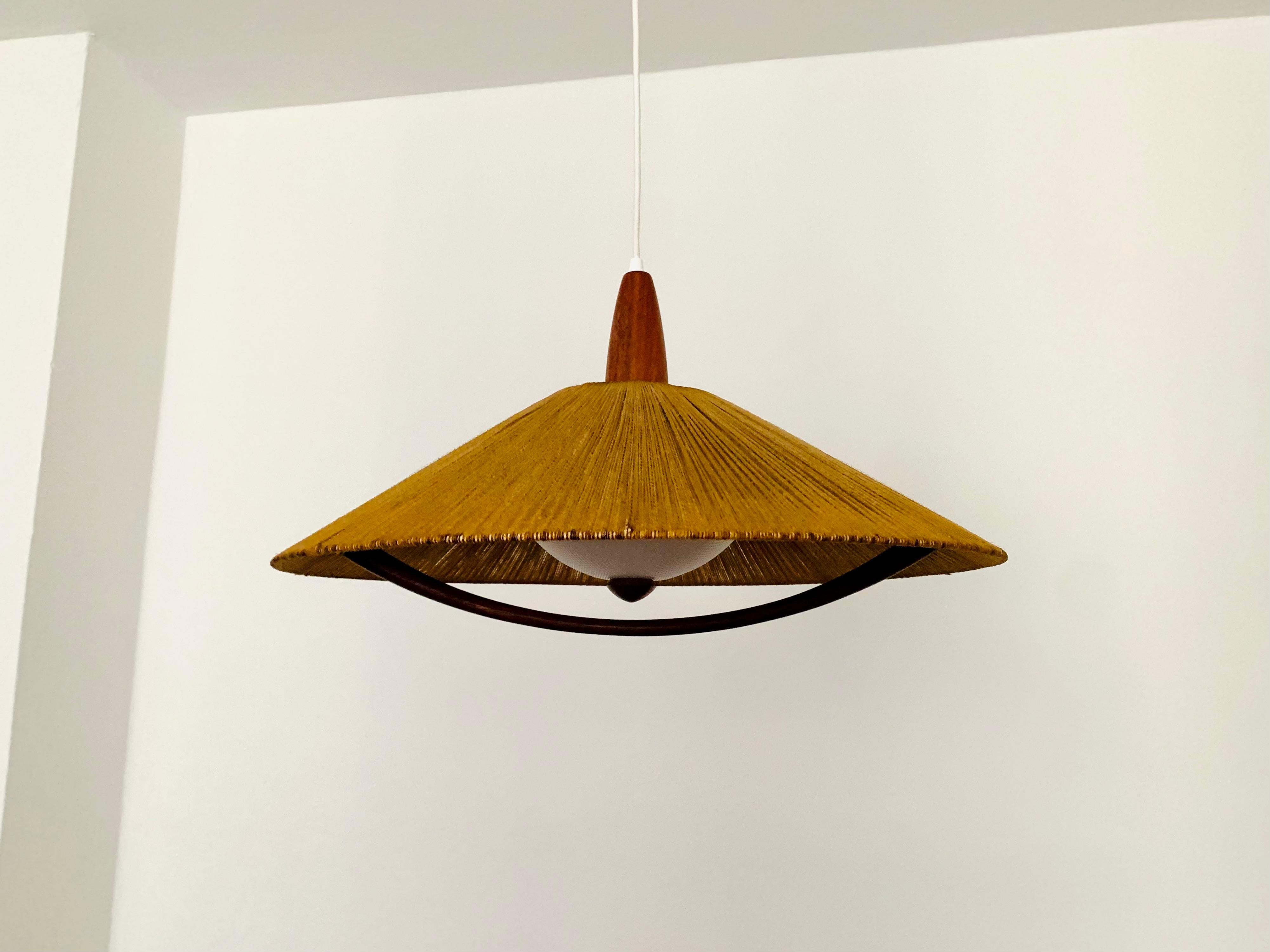 Exceptionally beautiful and large pendant lamp from the 1960s.
The design is very unusual.
The shape and the materials create a warm and very pleasant light.
The teak details are beautifully shaped.

Condition:

Good vintage condition with