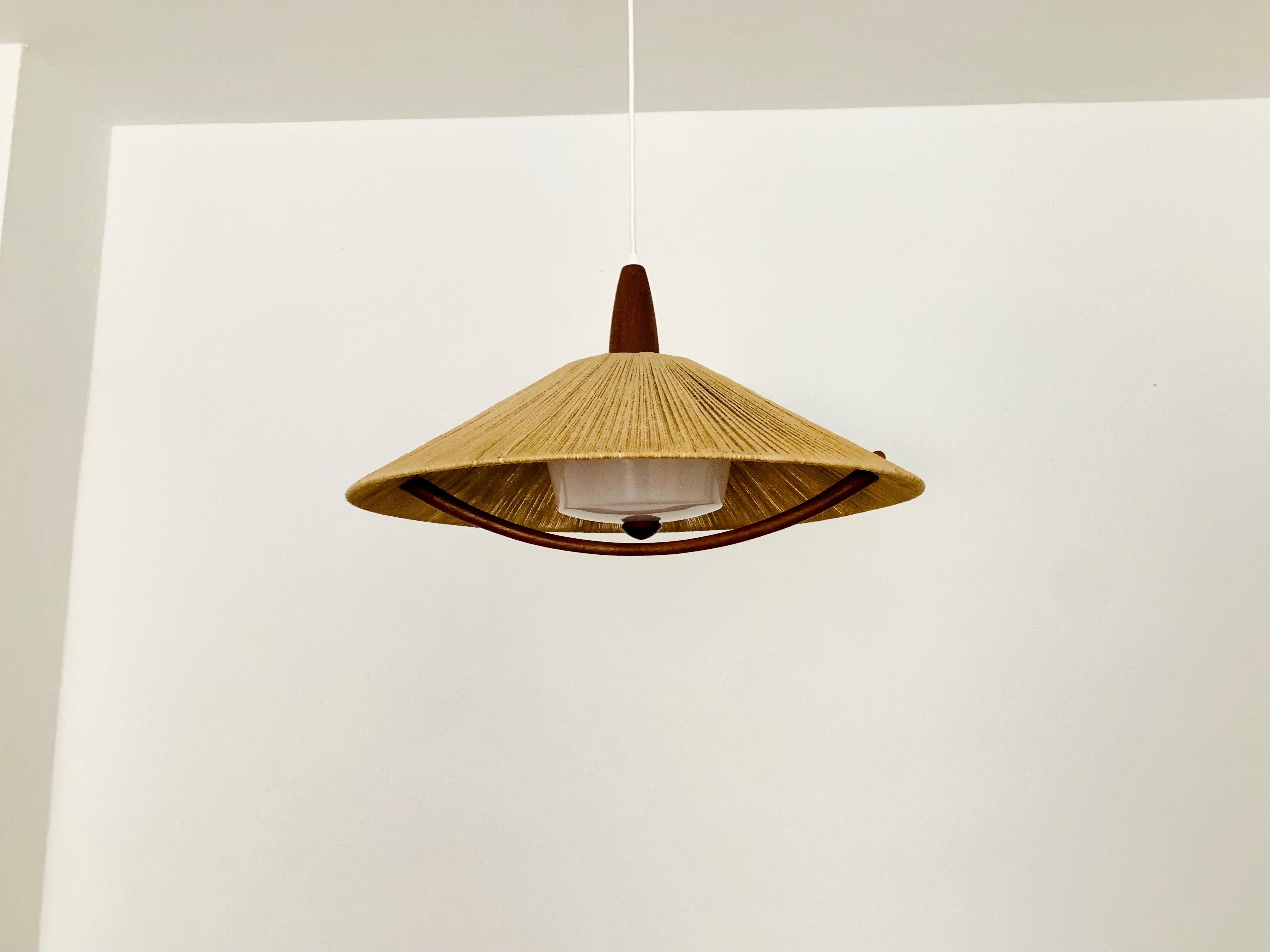 Exceptionally beautiful and large pendant lamp from the 1960s.
The design is very unusual.
The shape and the materials create a warm and very pleasant light.
The teak details are beautifully shaped.

Condition:

Very good vintage condition with