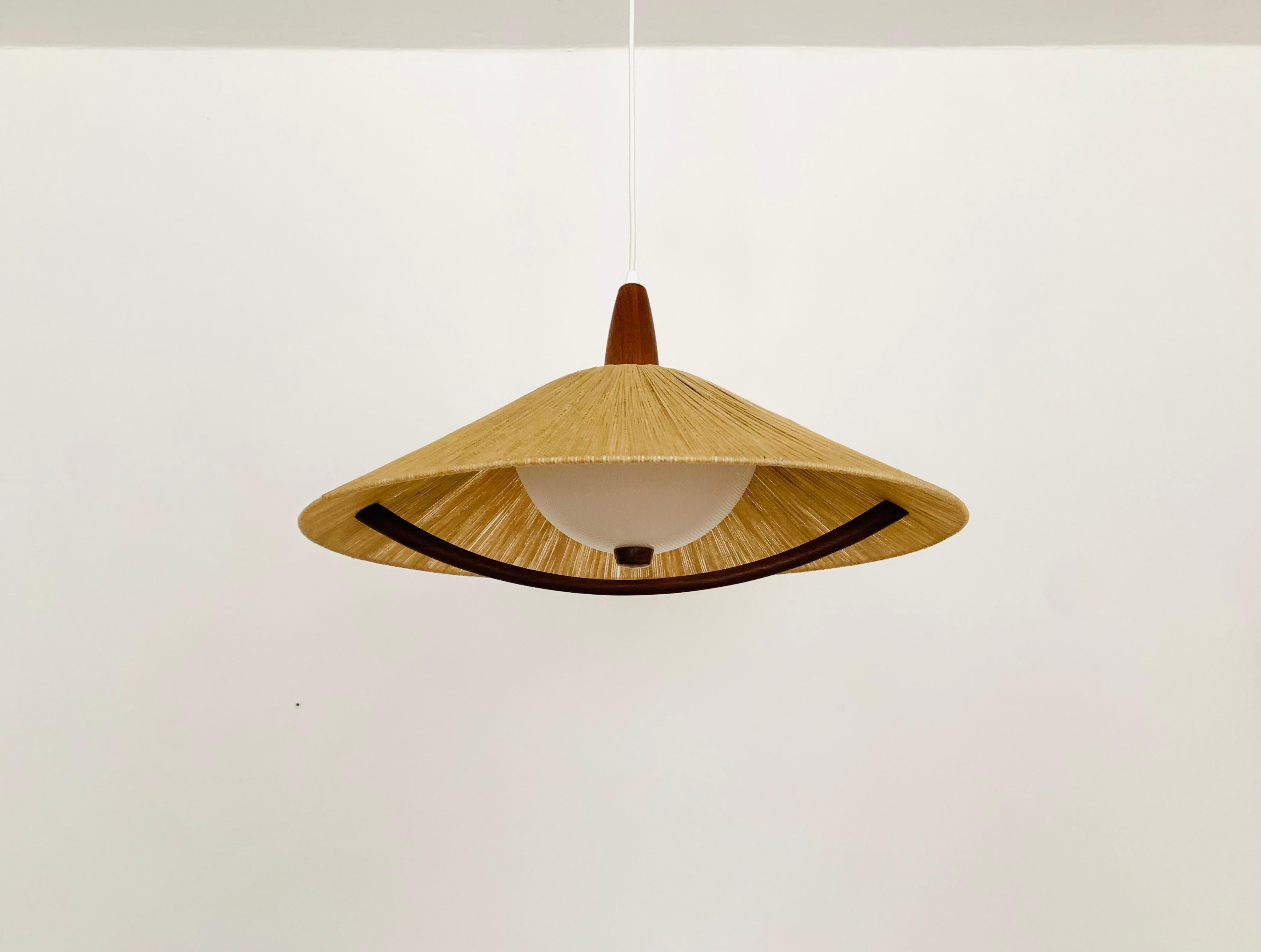 Exceptionally beautiful and large pendant light from the 1960s.
The design is very unusual.
The shape and the materials create a warm and very pleasant light.
The teak details are beautifully shaped.

Condition:

Very good vintage condition with