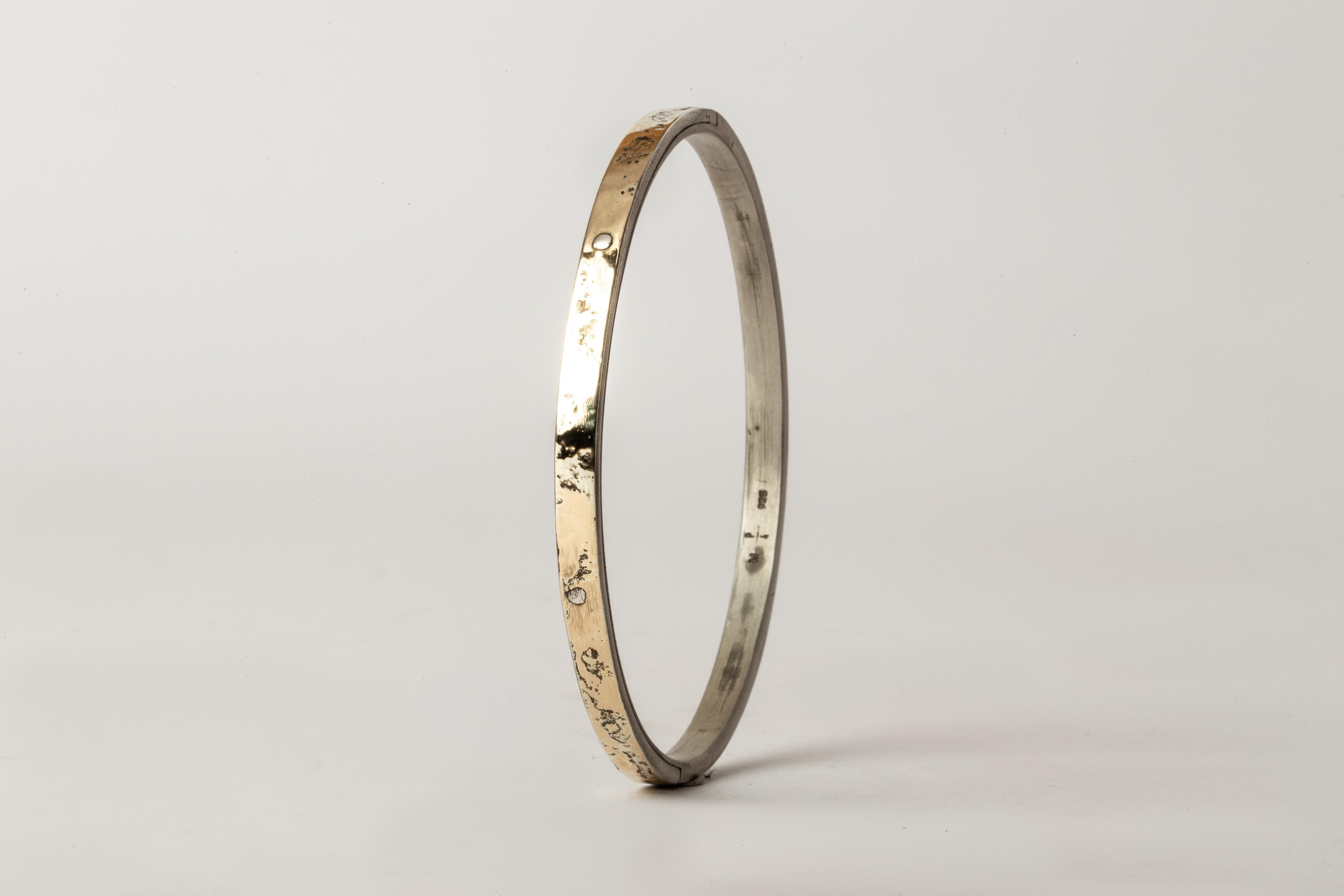 Bracelet in acid treated sterling silver with fused layer of 18k yellow gold.
The Sistema series is first family within Parts of Four. As a mode of creation it expresses the core principle of P/4 which is modularity. The 