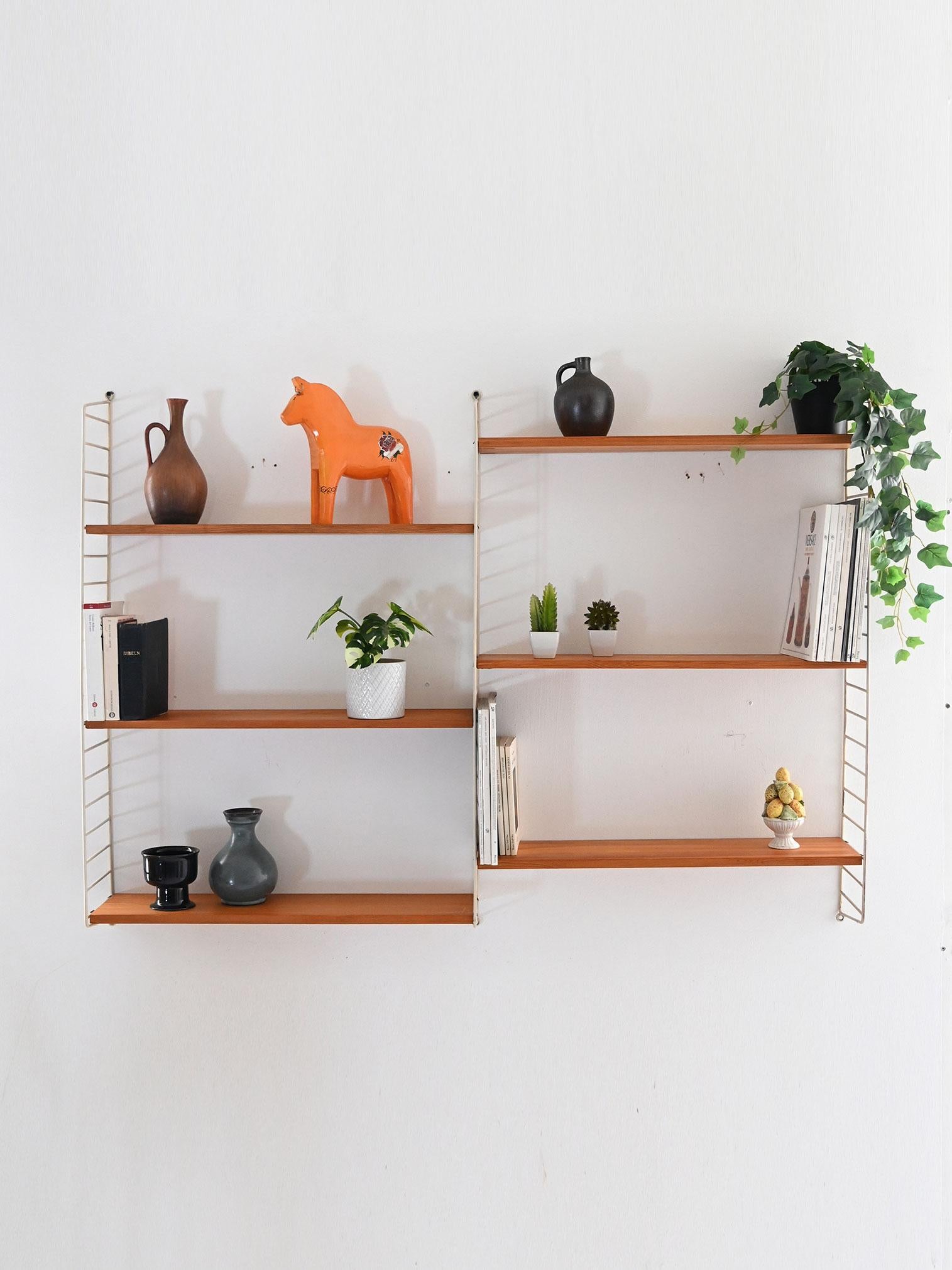 Modulares System zur Wandmontage mit sechs verstellbaren Regalen aus Tannenholz und weiß lackiertem Metallrahmen.

Skandinavisches Wandsystem aus den 1960er Jahren, bestehend aus sechs Regalen aus Tannenholz und einem weiß lackierten Metallrahmen.