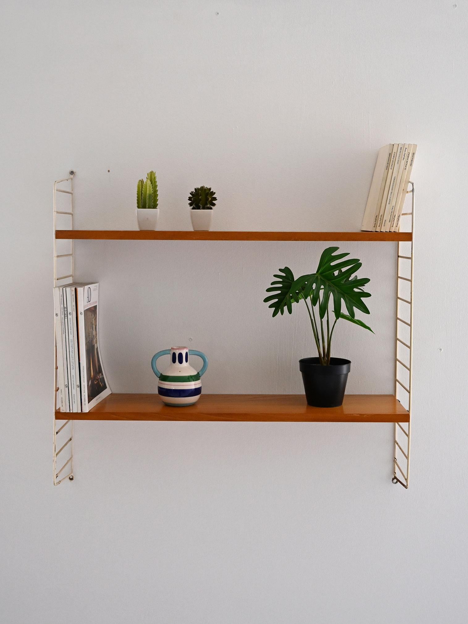 Mensole a muro vintage con struttura metallica bianca e due ripiani in rovere regolabili in altezza.

Sistema modulare a parete di ispirazione scandinava, con struttura laterale in metallo verniciato bianco e due ripiani in rovere. Le mensole
