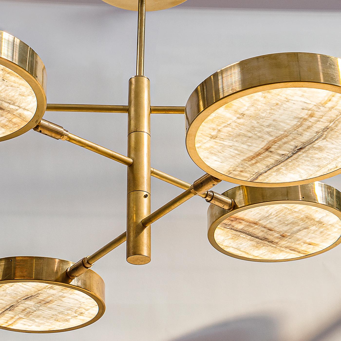 Sistema Solare è la variante del lampadario Sistema in cui il paralume è costituito da una lastra di onice avorio tagliata sottile. La collezione Sistema utilizza la struttura a stelo rotante di successo della collezione Orbitale e presenta un basso