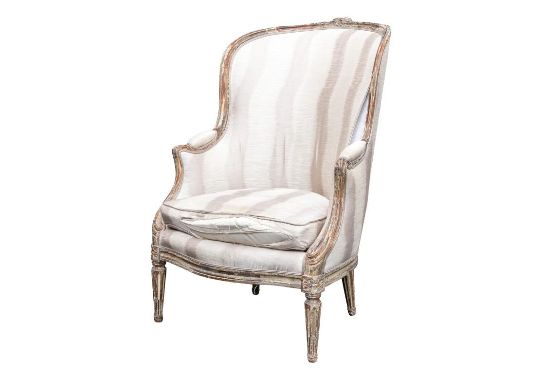 Louis XVI painted bergere having a sineous frame with time worn carvings, circa 3rd quarter 18th c. The chair with tight back, manchettes, back center support and resting on fluted legs. Once belonging to Sister Parish. 

Dimensions: 28
