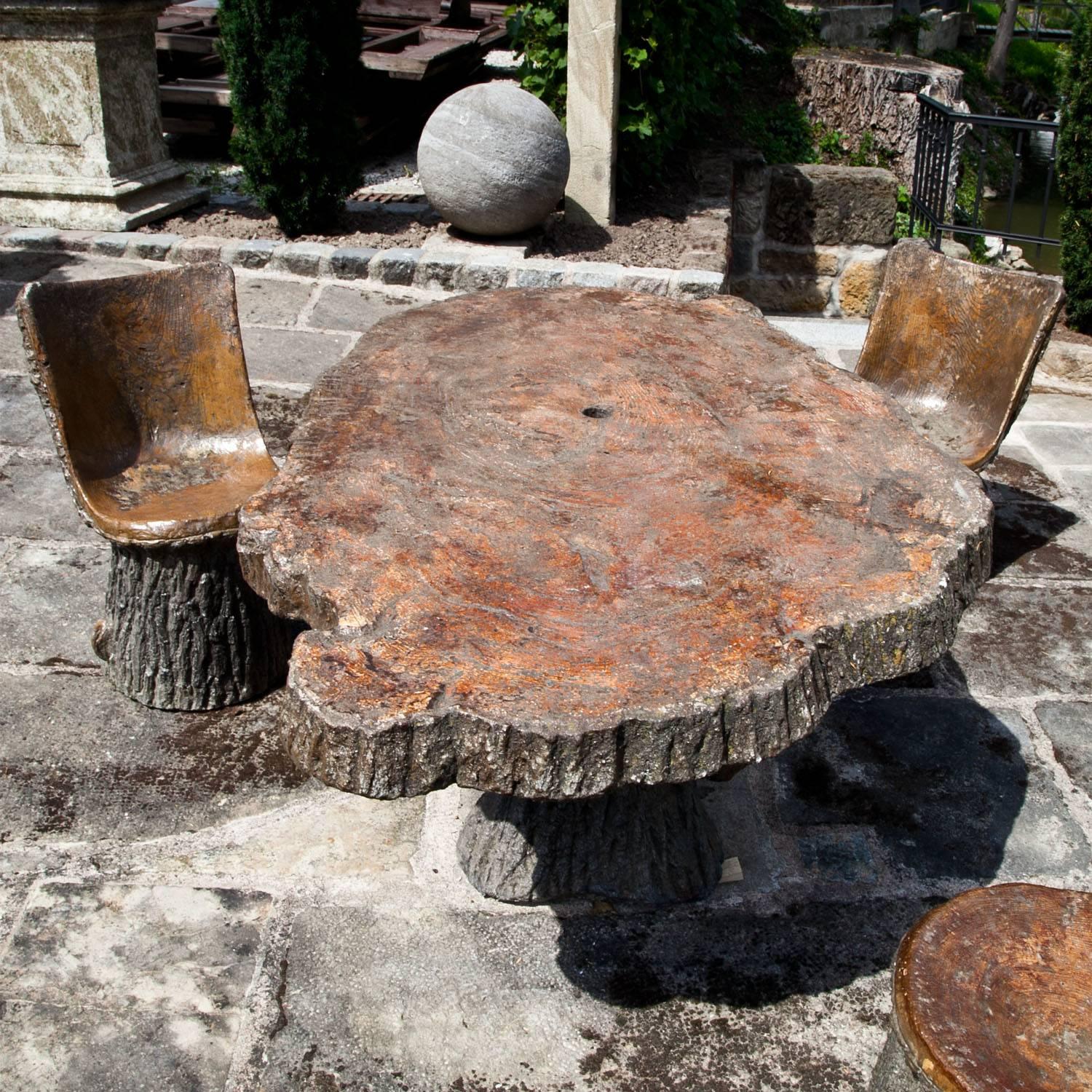 Sitting group consisting of three chairs and one table out of concrete. The surface was modeled after tree bark and painted accordingly. The tabletop has a hole for a parasol.

Table in cm 74 x 158 x 100.