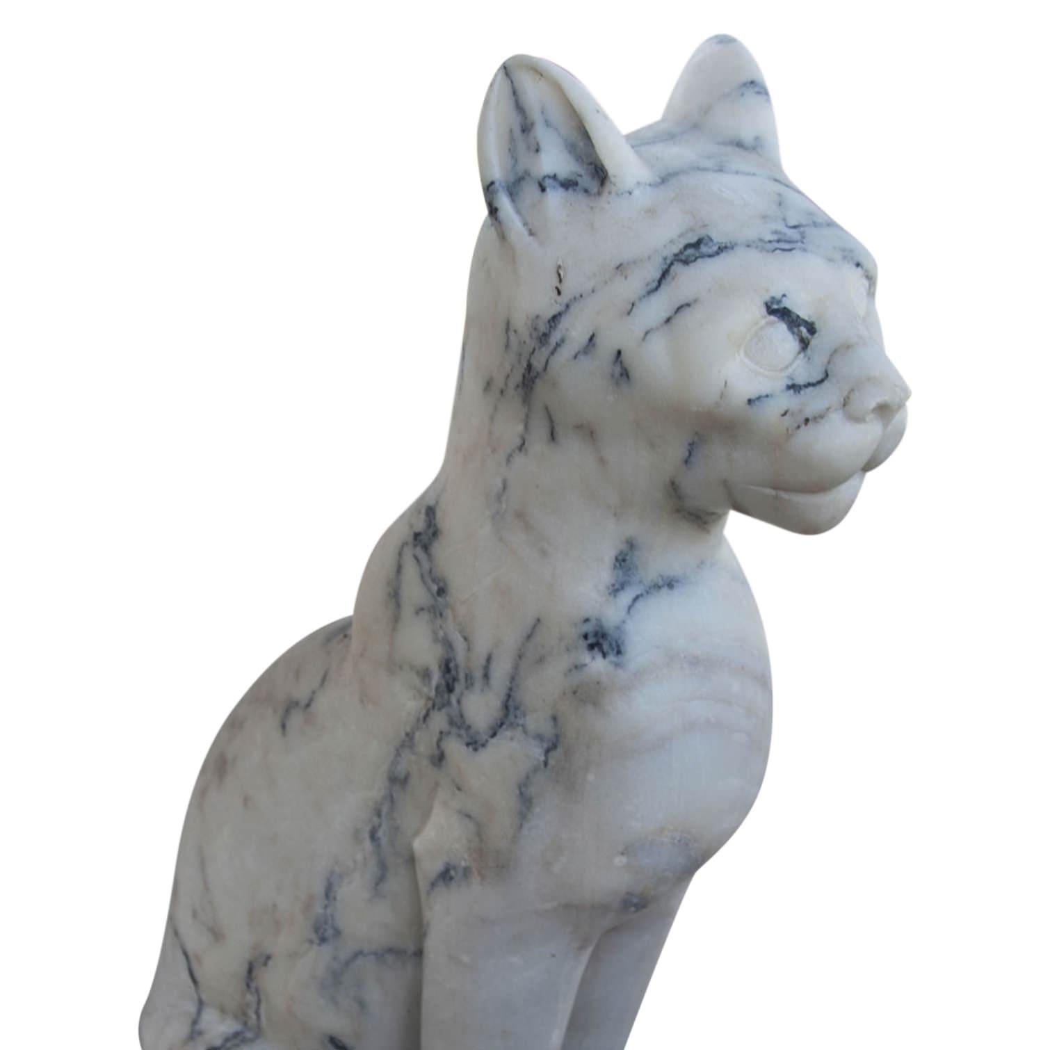 Hand-carved cat out of white marble with black veins. The cat is depicted in a sitting posture on a rectangular base.