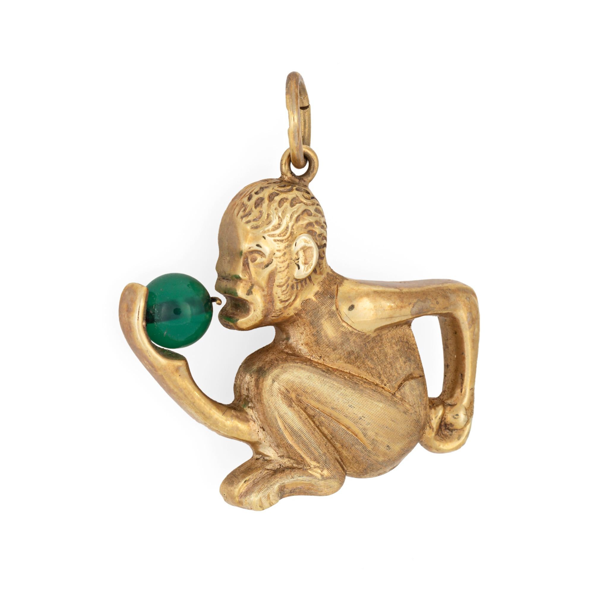 Finely detailed vintage monkey charm crafted in 14k yellow gold.  

Synthetic green stone measures 6mm. The sitting monkey is finely detailed with brushed gold texturing to the body. Medium sized in scale the charm is great worn alone or