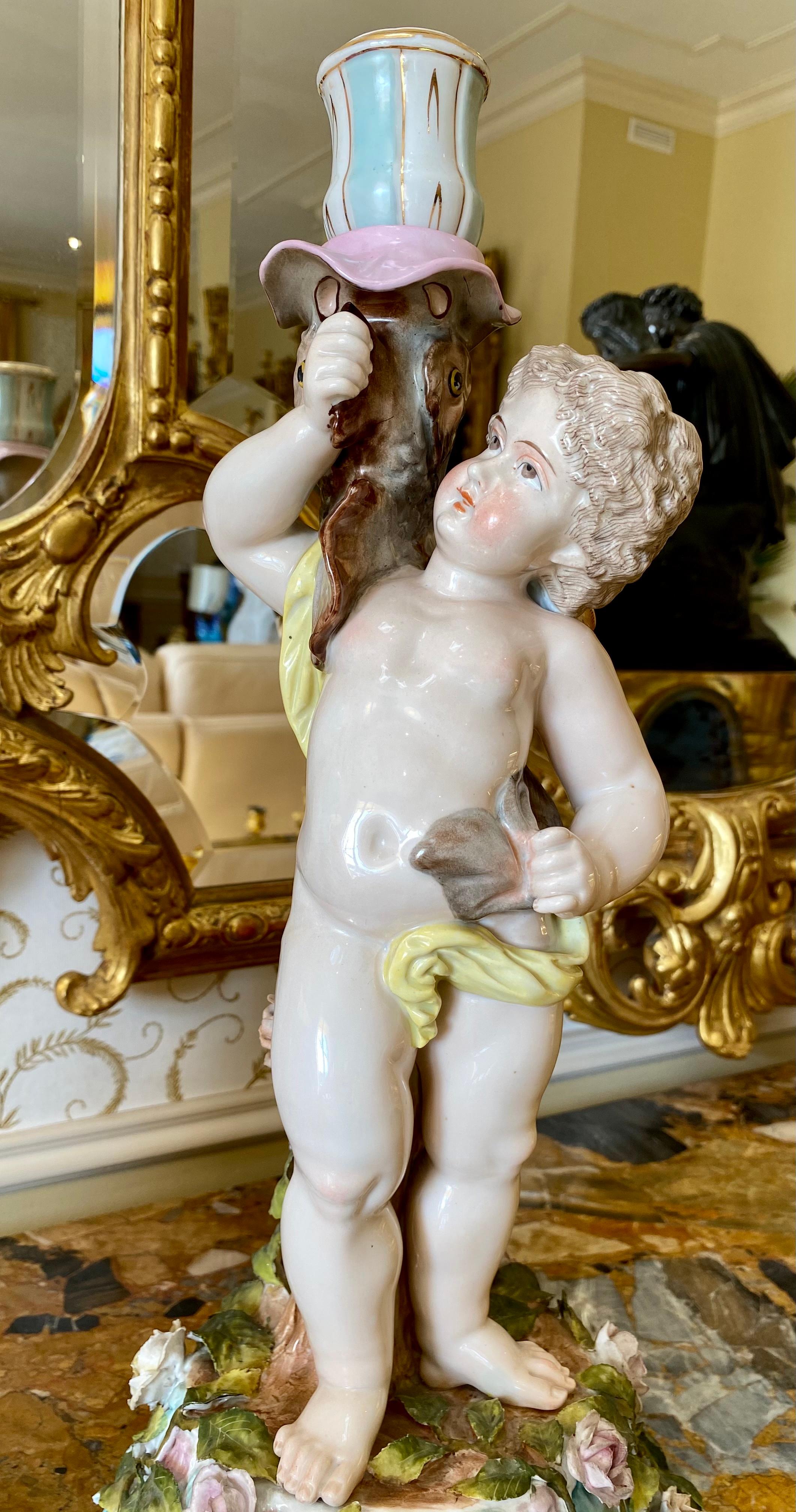 Beautiful pair of German porcelain candlesticks from Sitzendorf representing Venus, transformed into a fish, supported by her son Cupid in order to escape Thyphon in the waters of the Euphrates. These candlesticks are in very good condition,