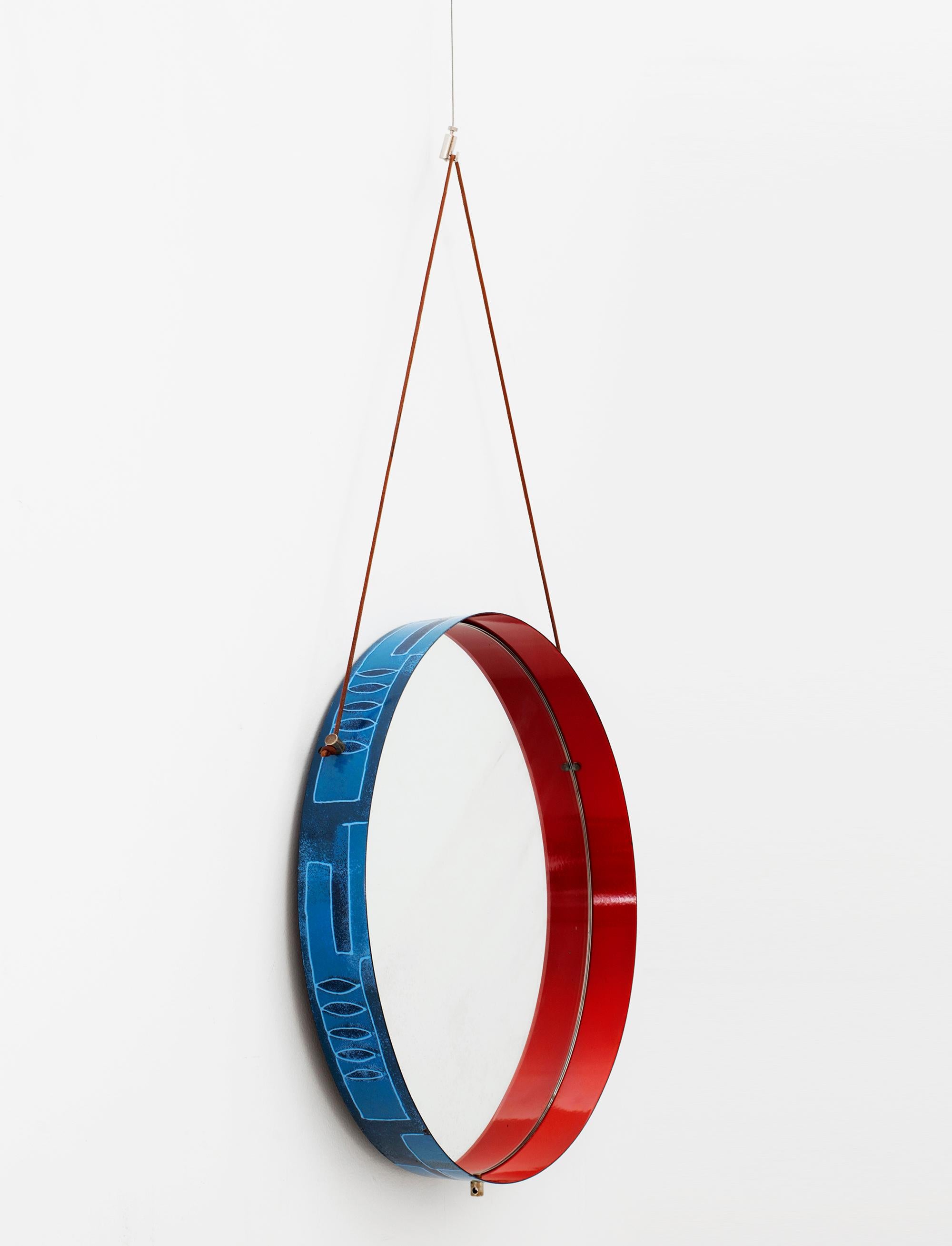 Stunning Italian circular wall mirror in blue and red ceramic on metal frame by Siva Poggibonsi. Exterior of frame has painted shades of blue with leaf and geometric design. Interior is painted in a deep red lacquer. Amazing primary colors excite