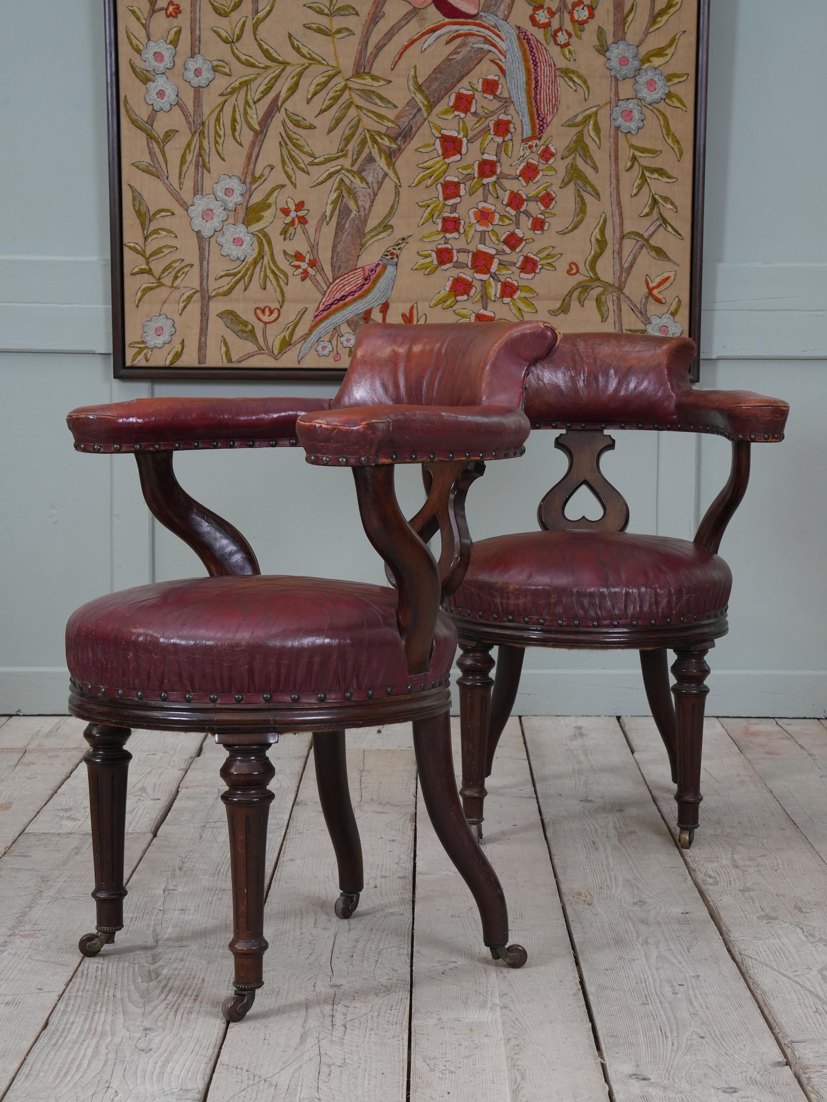 A run of oak and Moroccan leather library chairs.

Raised on glazed pot caster on turned tapering oak legs, Moroccan leather seat, back support and armrests, inverted heart motif back splat.

Priced individually, six available.