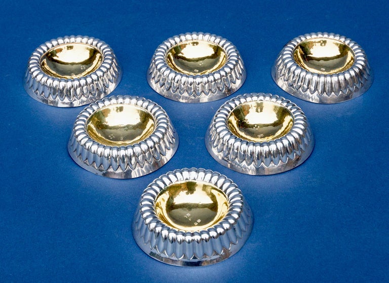 Six silver circular and partly fluted gilt-lined trenchers or spice dishes, one by Robert and Samuel Hennell, London, 1814 and five by Robert Dicker, London, 1870.