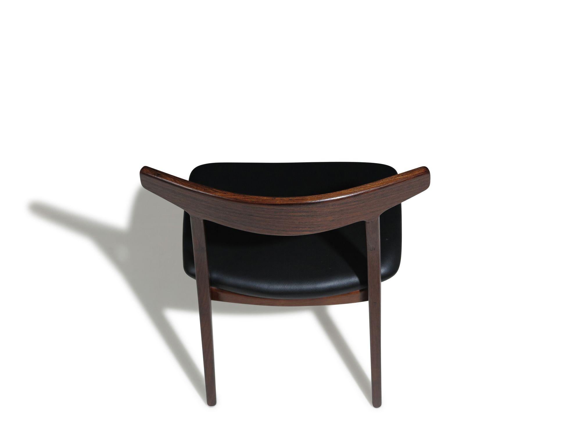 Six mid-century Brazilian rosewood dining chairs designed by Henning Kjaernulf and expertly crafted by Christensen & Larsen, Denmark. These Scandinavian dining chairs feature solid rosewood frames, elegantly curved minimalist backs, and fine joinery