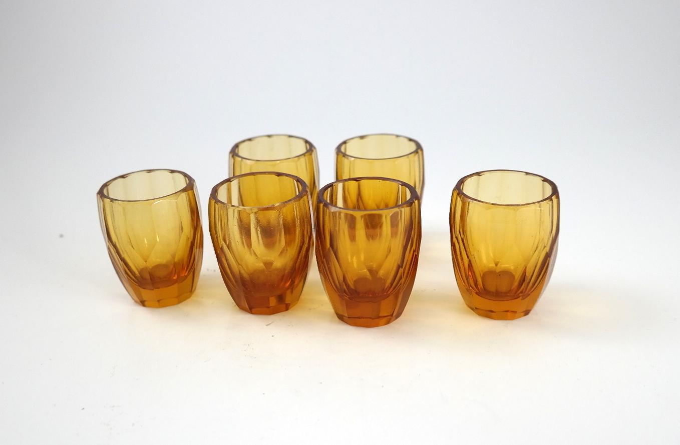 Six amber liquor glasses in oak case, 1970s.