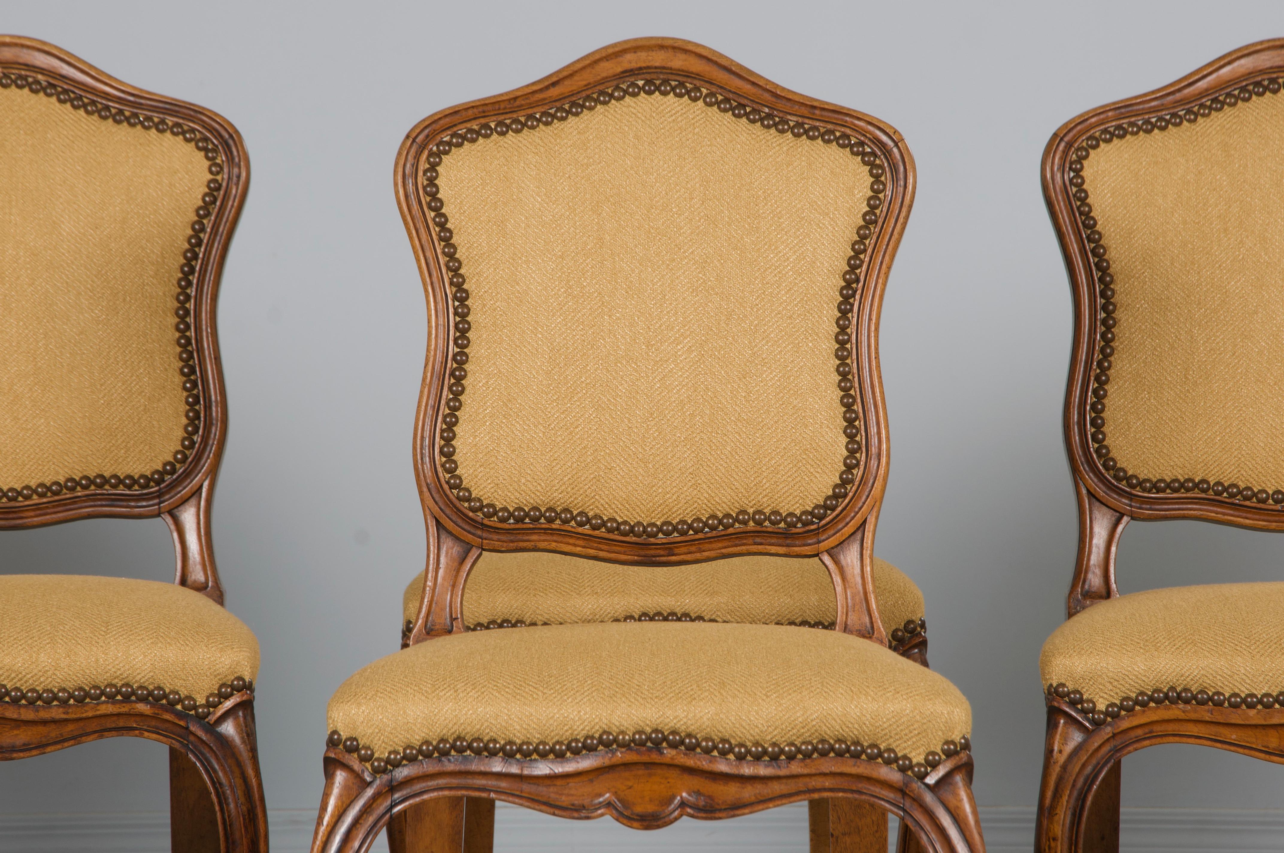 Ein eleganter, restaurierter Satz von sechs französischen Esszimmerstühlen im Stil Louis XV aus dem späten 19. Jahrhundert, die aus der Provence stammen. Jeder Stuhl ist aus massivem Nussbaumholz handgeschnitzt und verfügt über einen zierlichen,