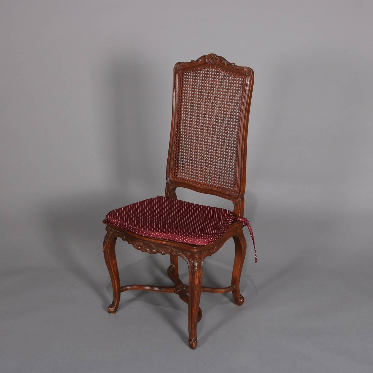 Set of six French Louis XVI carved mahogany tall back dining chairs feature caned backs and seats, scalloped and foliate aprons, raised on cabriole legs with x-form stretchers, circa 1900.

Measures: 44.5