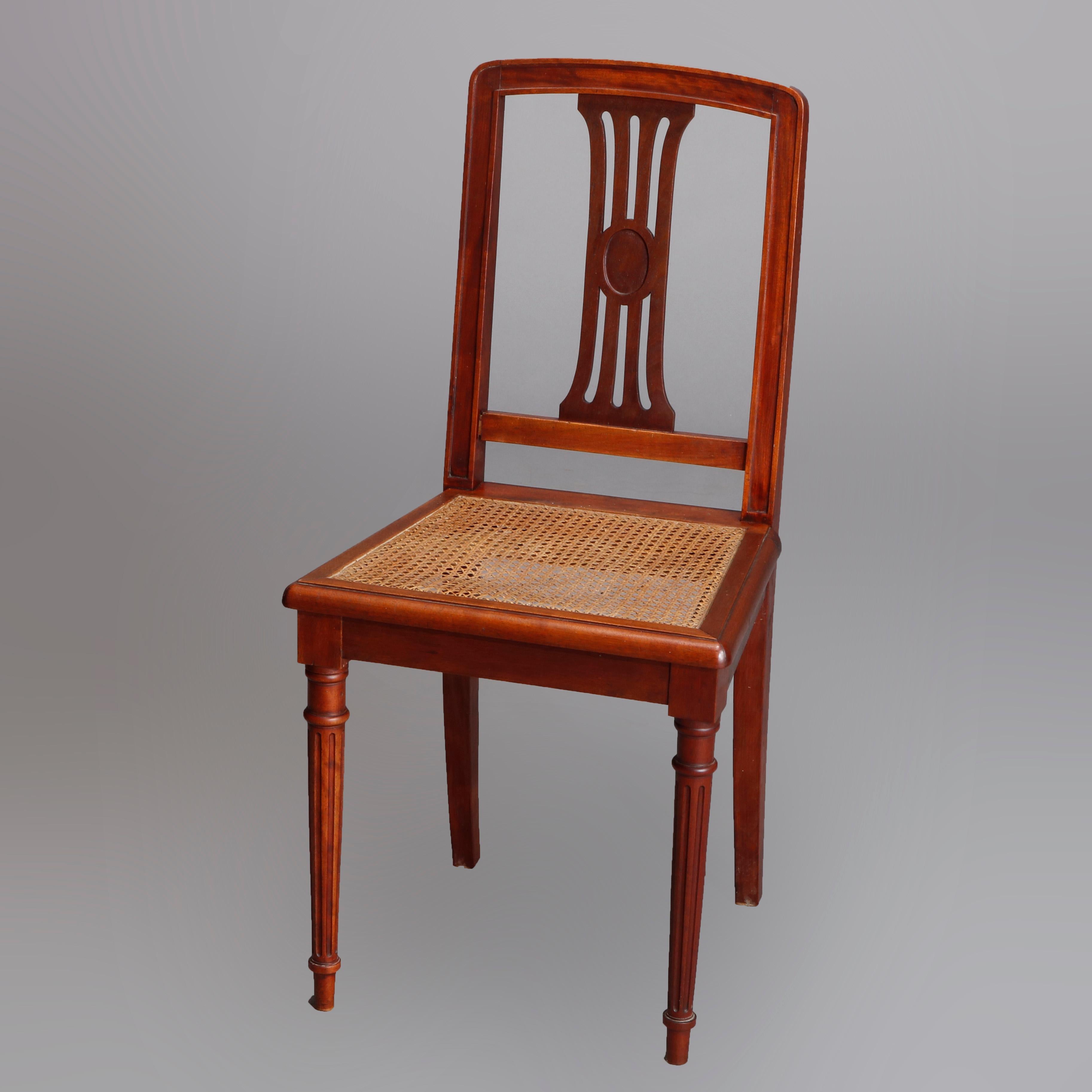 Set of six antique French Louis XVI dining chairs with mahogany frame having slat back over cane seat and raised on reeded tapered legs and feet, early 20th century

Measures: 36.25