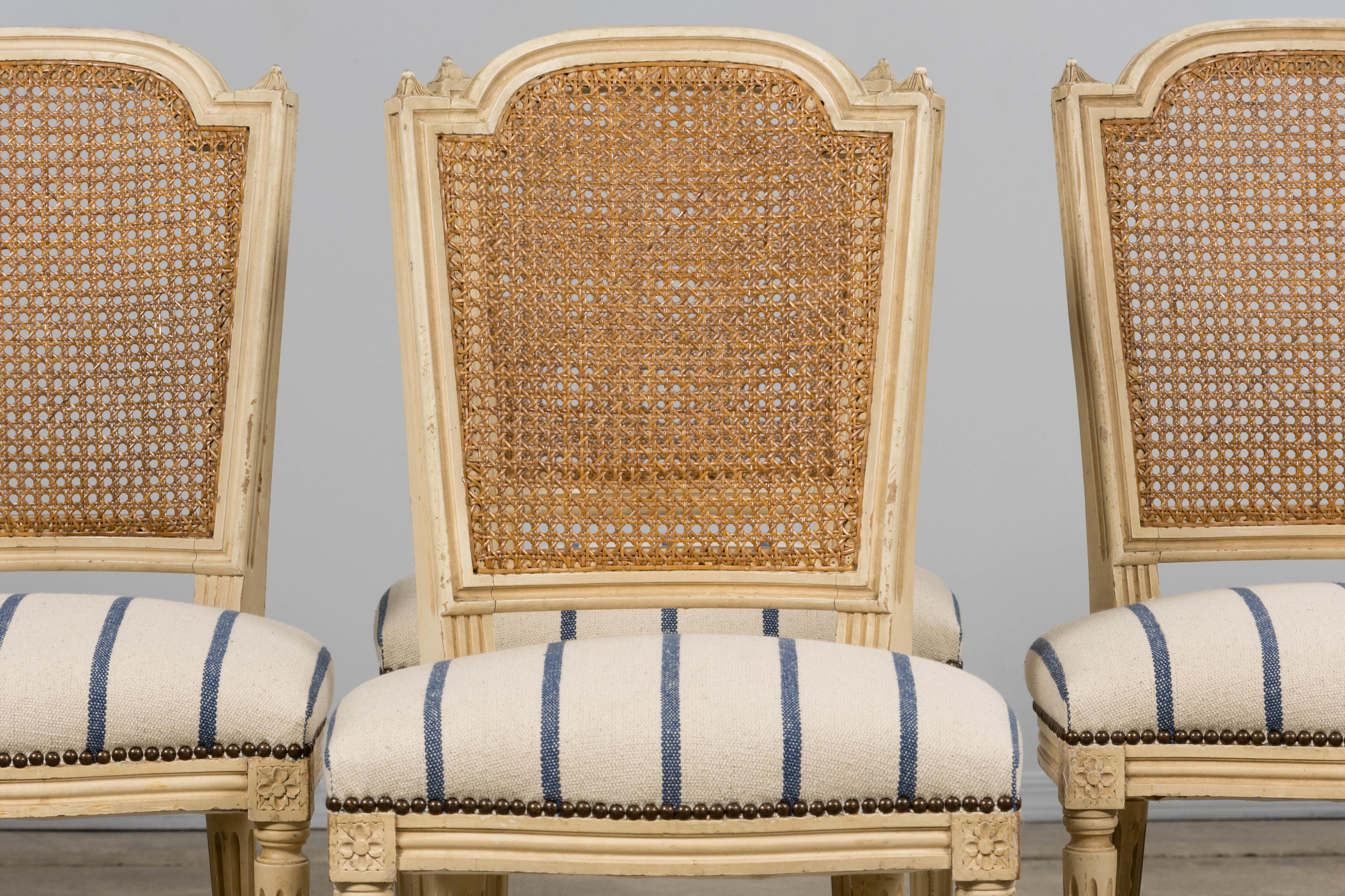 Encantador juego de seis sillas de comedor francesas de estilo Luis XVI de principios del siglo XX, procedentes de la Provenza. Cada silla está fabricada a mano en madera maciza con su acabado original pintado en un suave tono crema, envejecido de