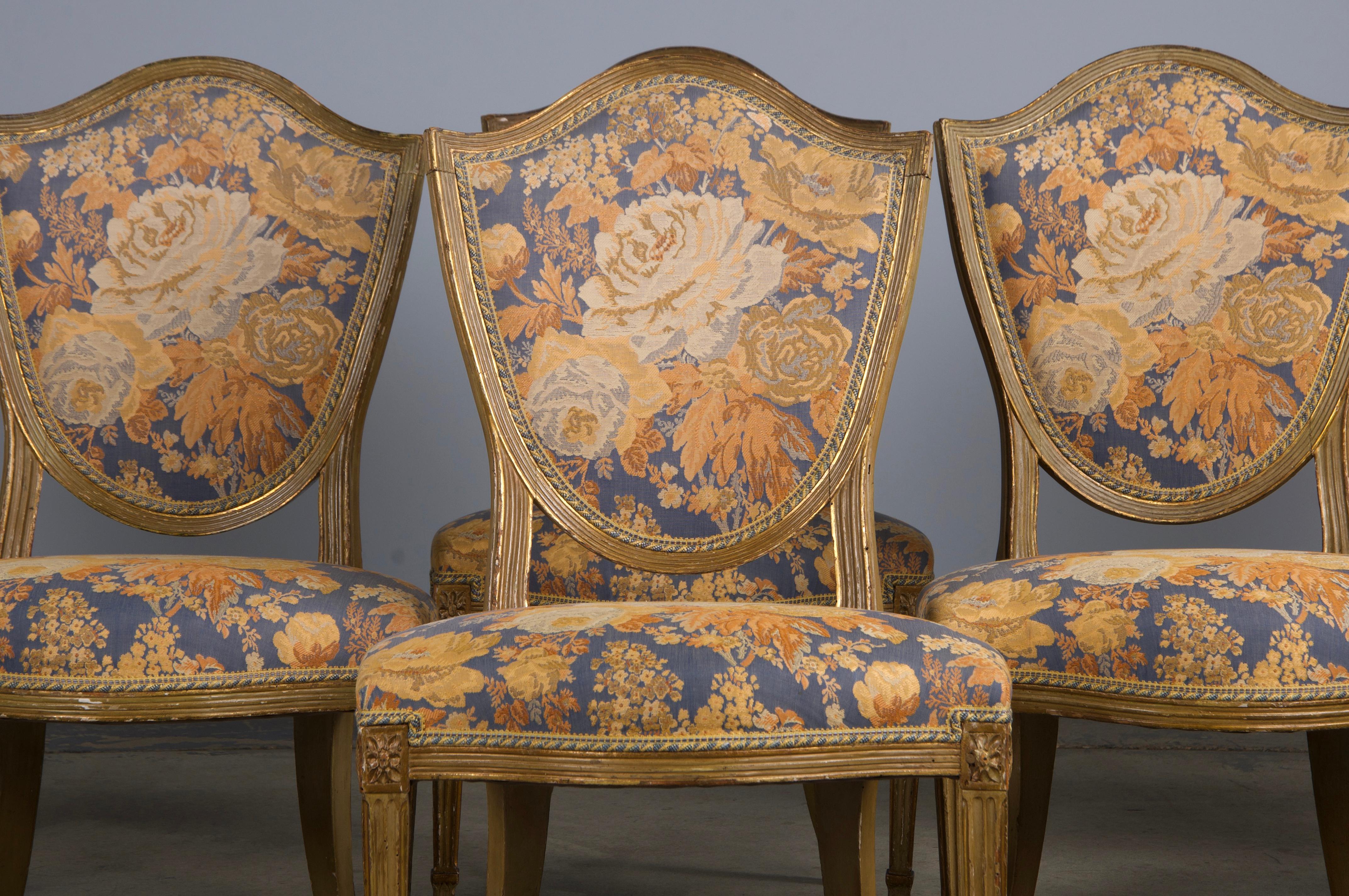 An exquisite and rare set of six late 19th-century French dining chairs crafted in the Neoclassical Louis XVI style, sourced directly from Paris. These chairs feature beautifully hand-carved solid wood frames with elegant shield-shaped backs.