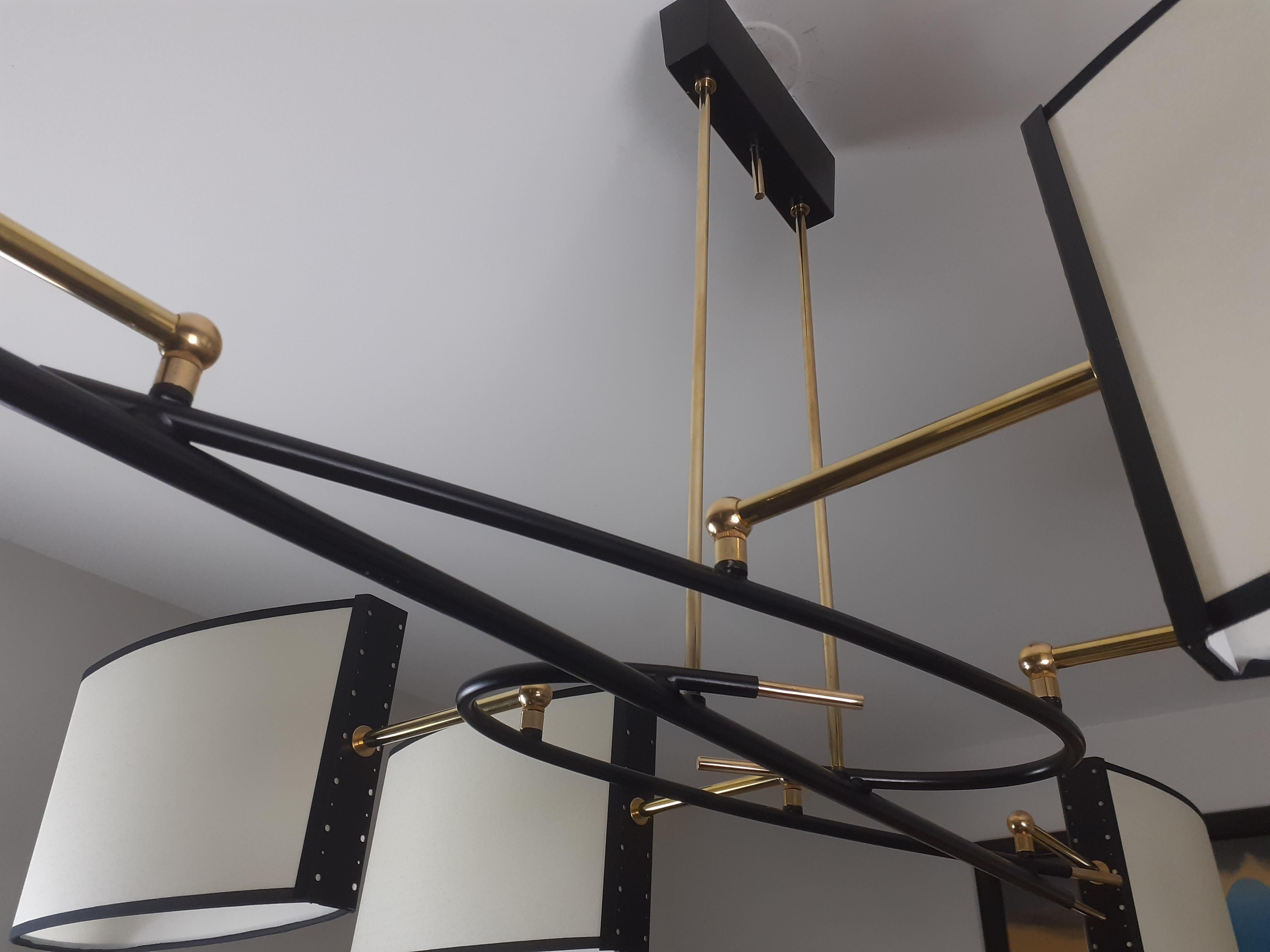 Six-arm chandelier in brass and black lacquered metal.
Oval lampshades arranged asymmetrically.
French work by R. Lunel, circa 1950.
This chandelier has been completely restored, the wiring is new and complies with European standards, and the