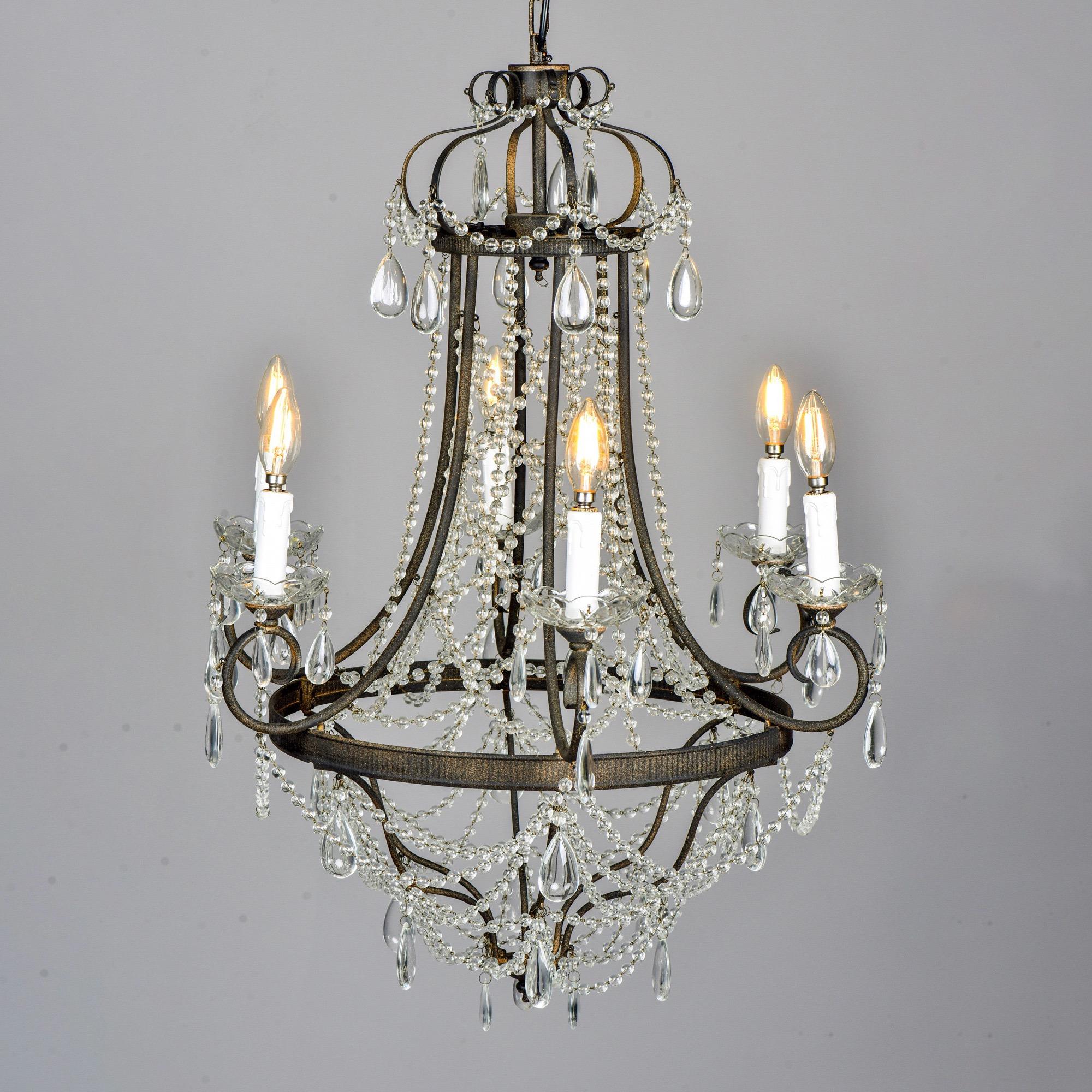 Dark iron framed chandelier with six candle arms and round crystal beading. Found in England. Unknown maker. New wiring for US electrical standards.