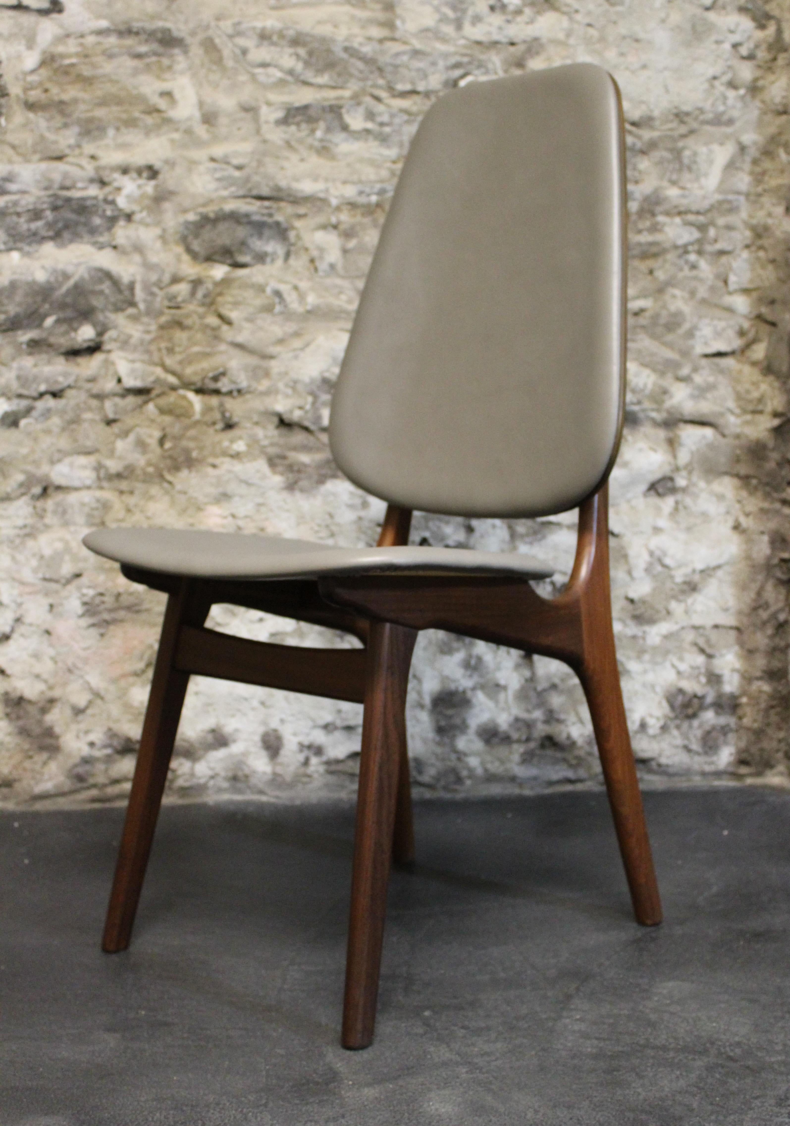 This lovely set of six Danish modern teak shield-back dining chairs were designed by Arne Hovmand-Olsen and are a rare version with tall upholstered backs which makes them exceptionally comfortable . The floating backrest is spaced by brass hardware