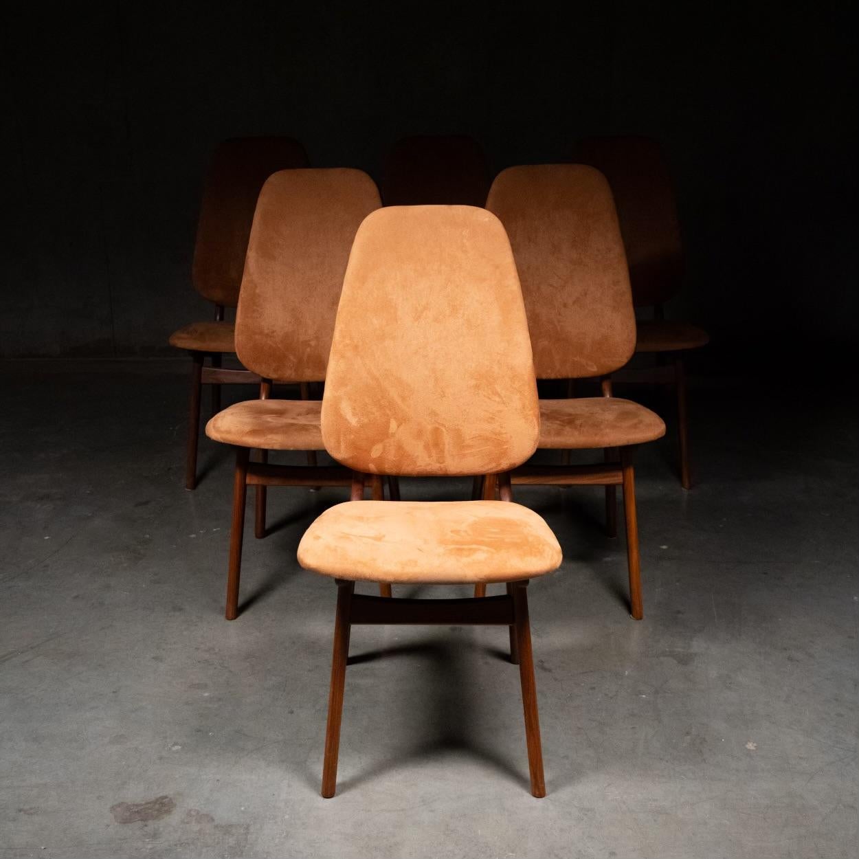 This set of six Danish modern teak shield-back dining chairs were designed by Arne Hovmand-Olsen and are a rare version with tall upholstered shield backs which makes them exceptionally comfortable . The floating backrest is spaced by brass hardware